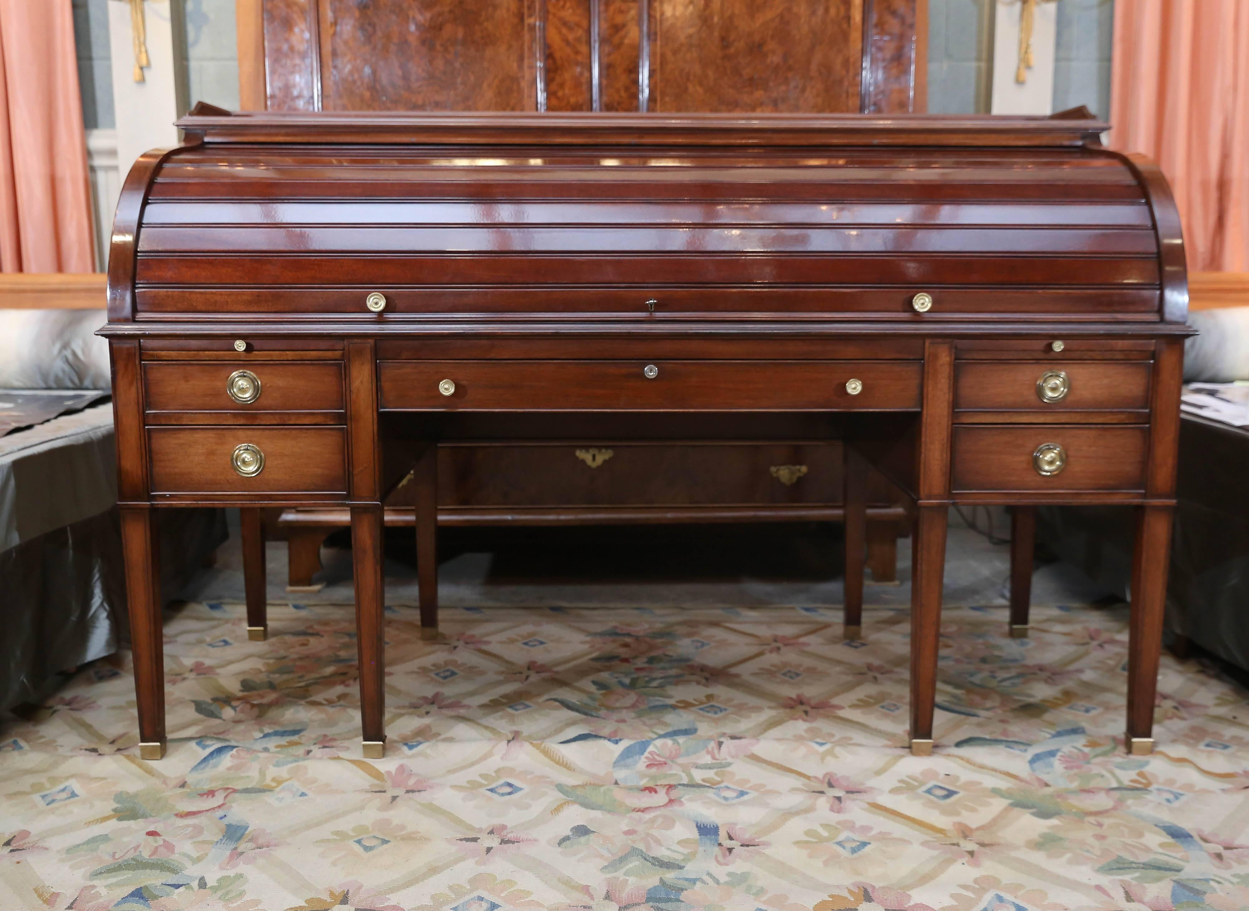  Hepple-White-style Executive Mahogany Roll-Top Desk custom made by Smith & Watson
The roll-top locks and has a gallery top on top.
Four  pigeon-hole drawers and a light sit above writing surface. A long center drawer with 2 drawers and 2 pull-outs