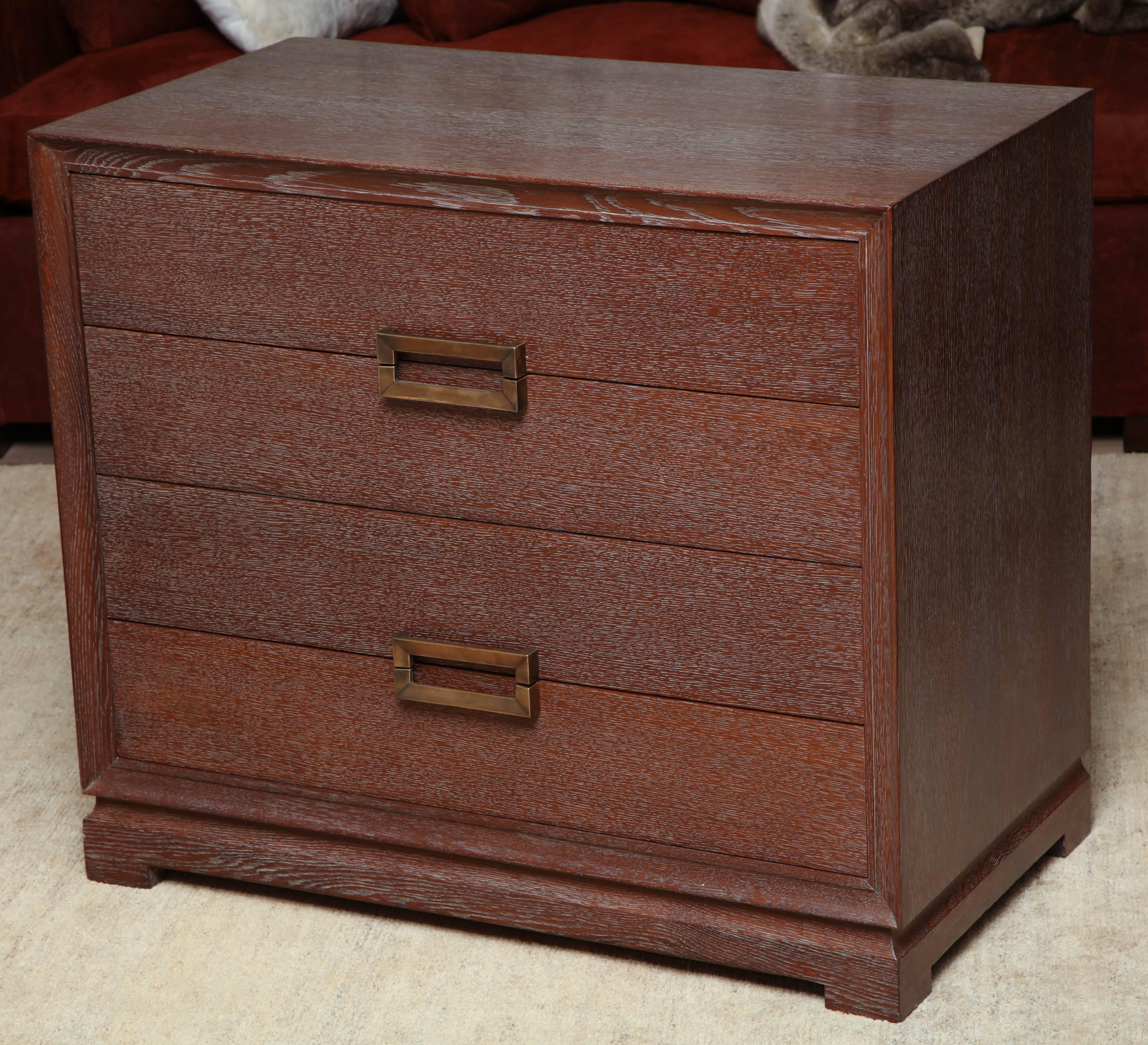 Four-drawer oak chest refinished in a burnt honey ceruse with patinated brass hardware in the manner of John Widdicomb, circa 1950.