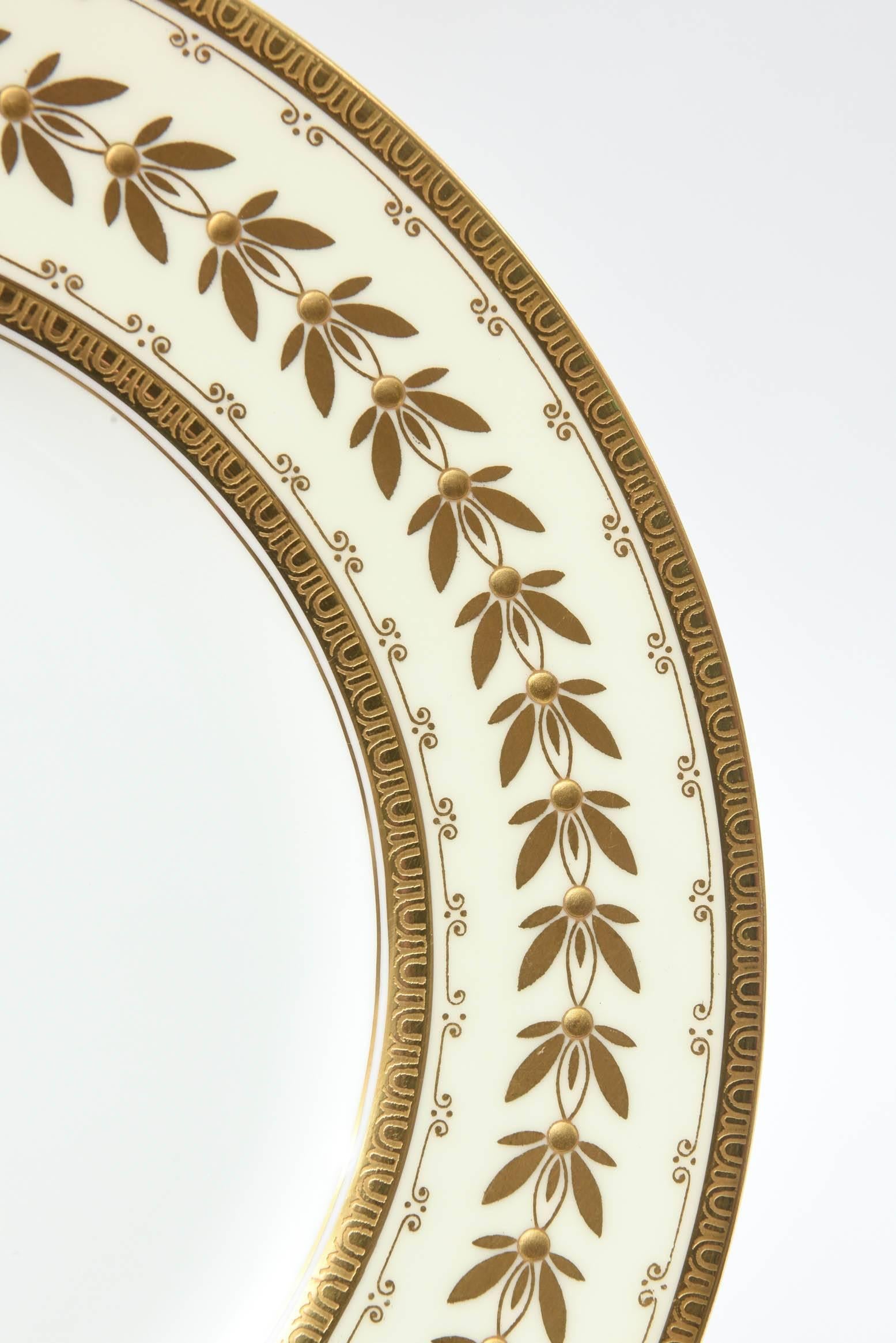 A classic and elegant set of dinner plates by Minton, England custom ordered through Tiffany & Co New York. These feature gilt edges and laurel leaf design with the centre of the design in raised paste gilding. Nice clear centres and in really great