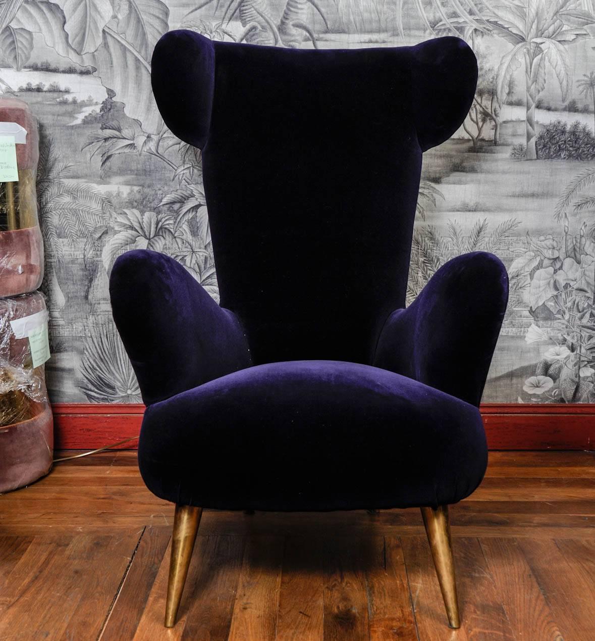 Pair of vintage wing armchairs with high back, four brass legs, upholstered with purple velvet.