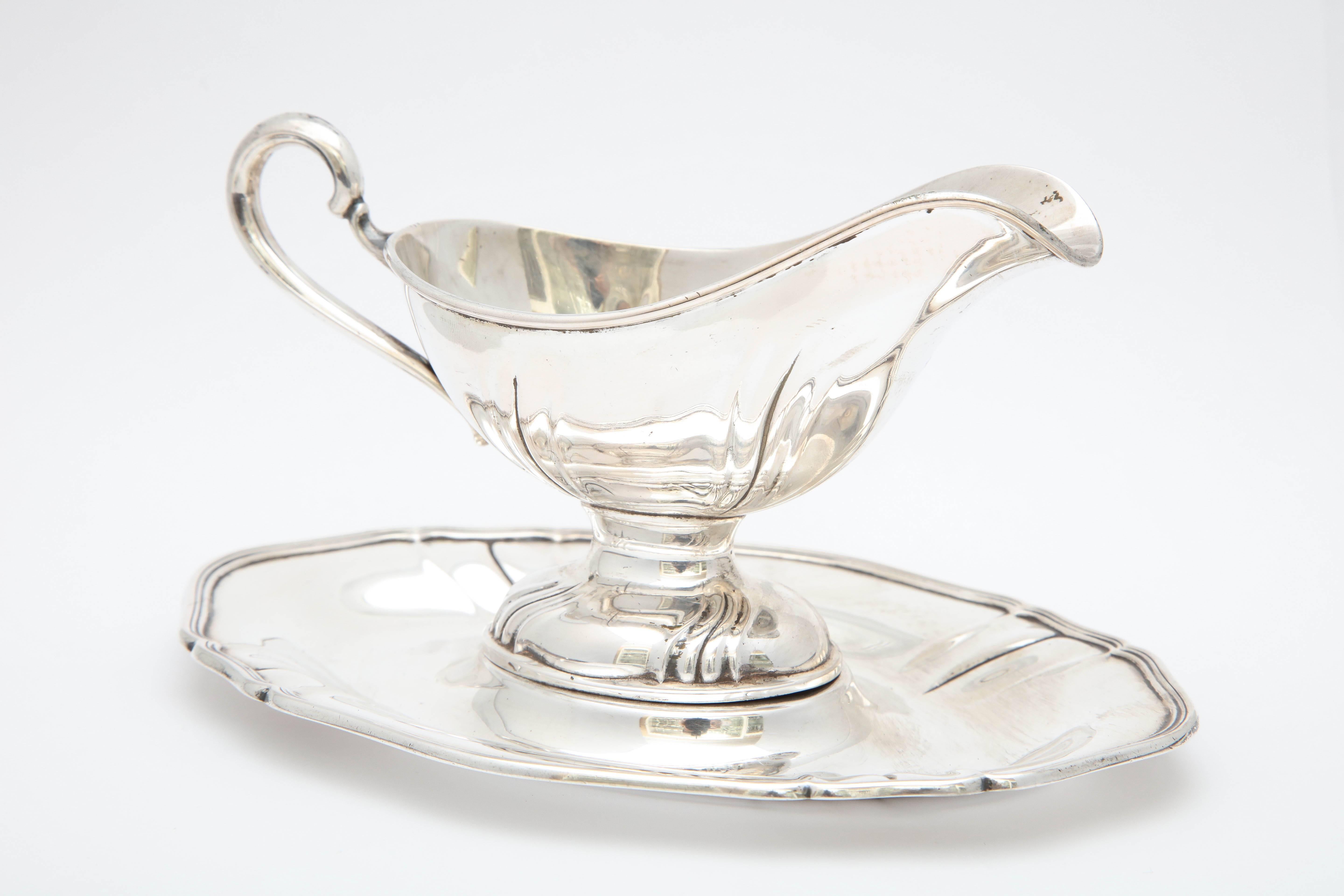 Victorian-style, Continental silver (.800) sauce/gravy boat on attached tray, Germany, circa 1910. Measures 4 inches high (at highest point) x 7 inches wide across tray x 5 inches deep. Weighs 5.690 troy ounces. Lovely swirled design. Small dint on
