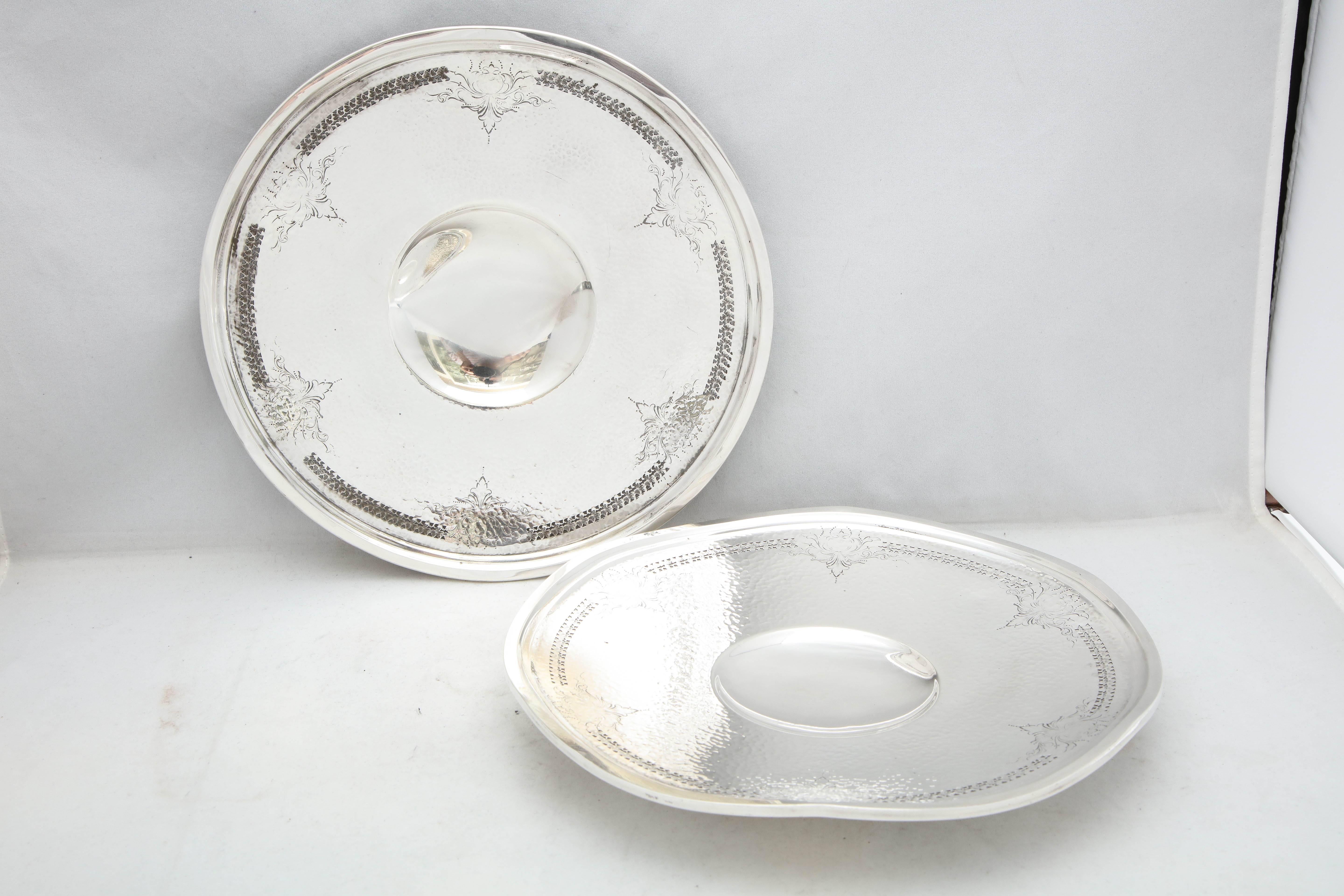 Pair of Art Deco, sterling silver, hand-hammered, pedestal based serving platters, The Webster Corp., No. Attleboro, Mass, circa 1920's-1930's. Design is hand-hammered and has etched and pierced work around borders. Edge if each platter is wavy as