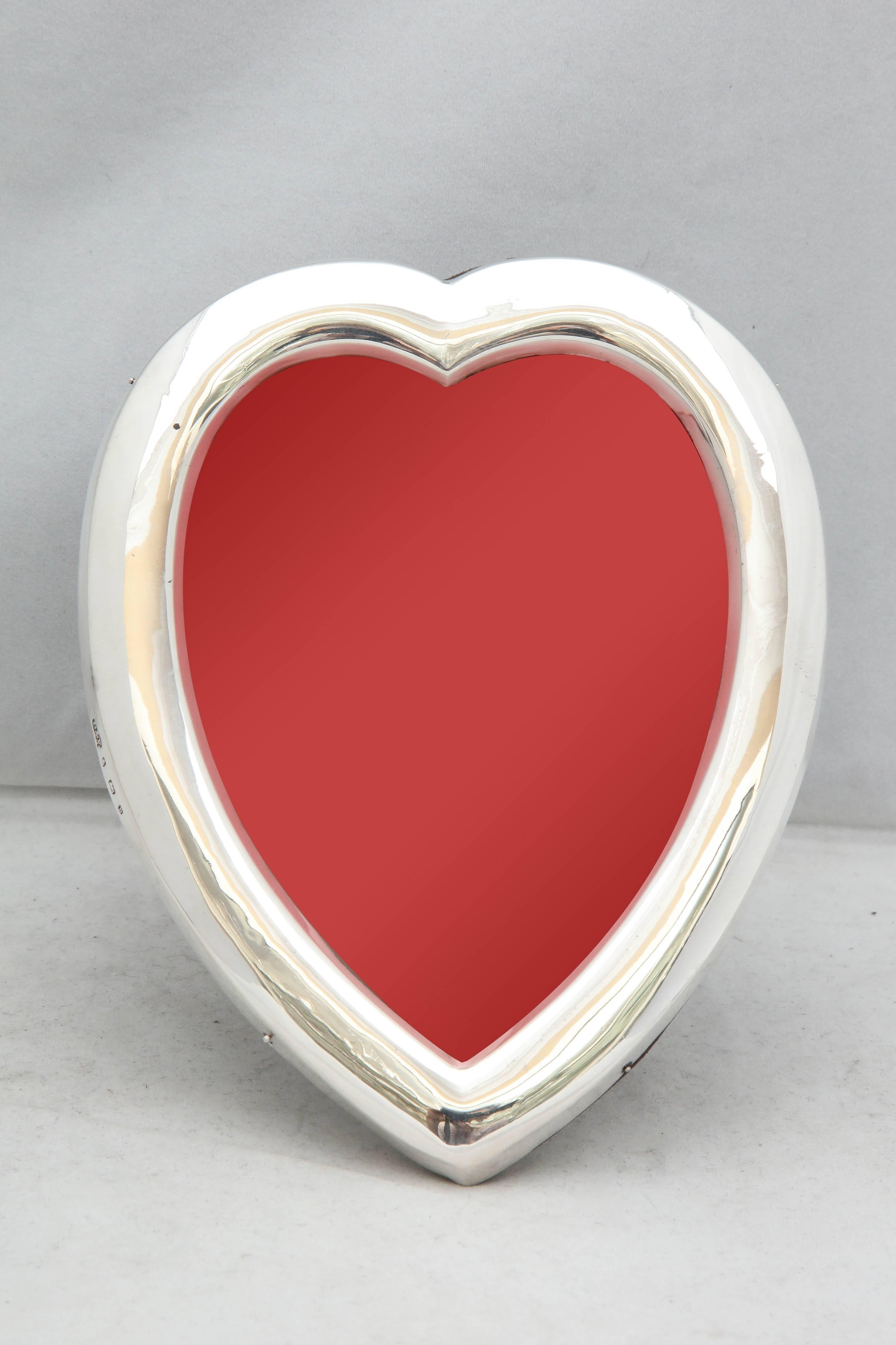 Edwardian, sterling silver heart-form picture frame, Birmingham, England, 1901, Deakin and Francis, Ltd. - makers. Brown leather back is hinged to allow insertion of photo. Stands 7 inches high x 5 1/2 inches wide at widest point x 5 1/2 inches deep