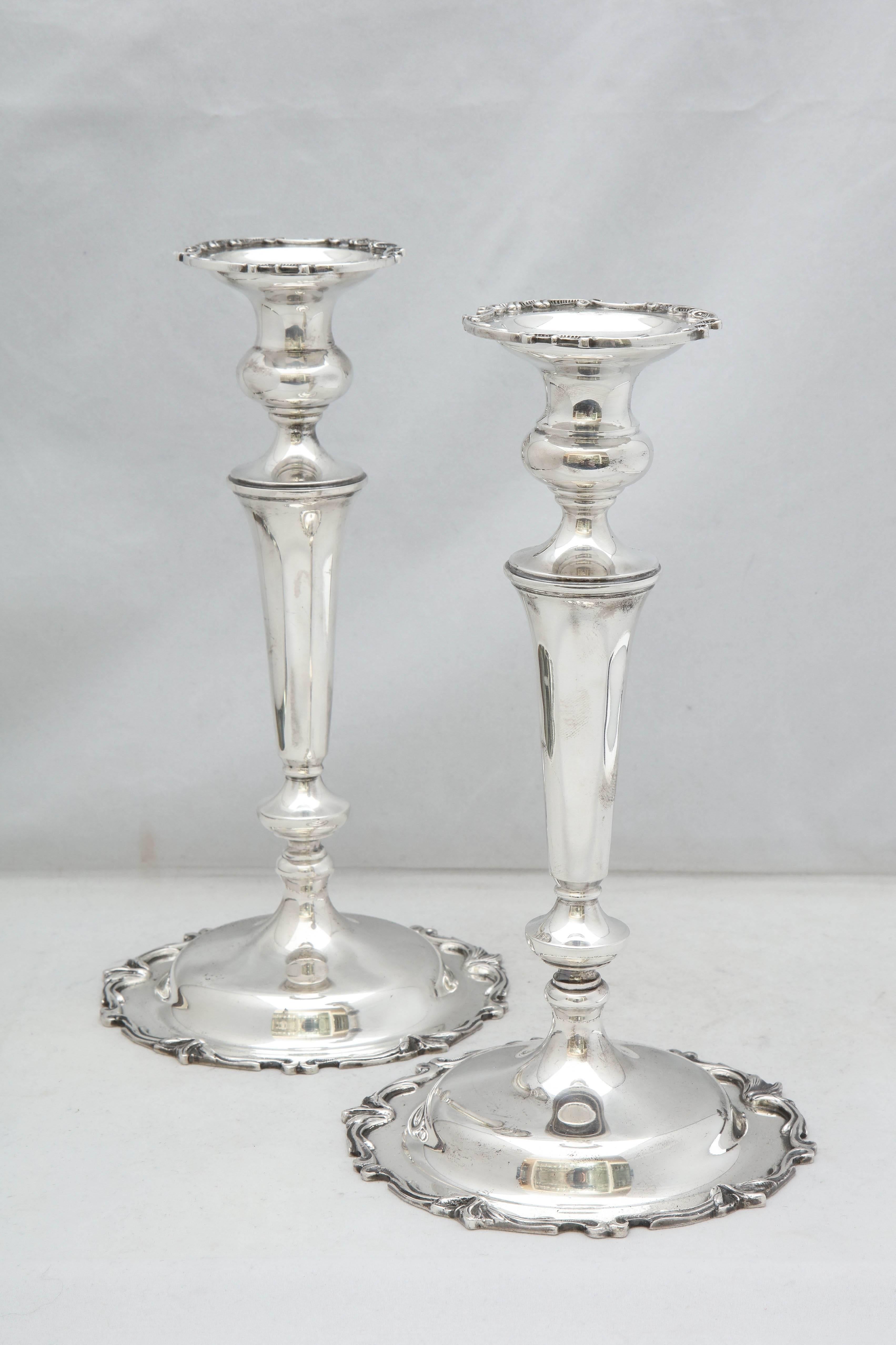 Pair of tall, sterling silver, Edwardian style candlesticks, Michael C. Fina Co., New York, circa 1930s. Measure approximately 10 1/8 inches high x over 5 1/2 inches in diameter across base of each. Design on edge of base of each is continued on