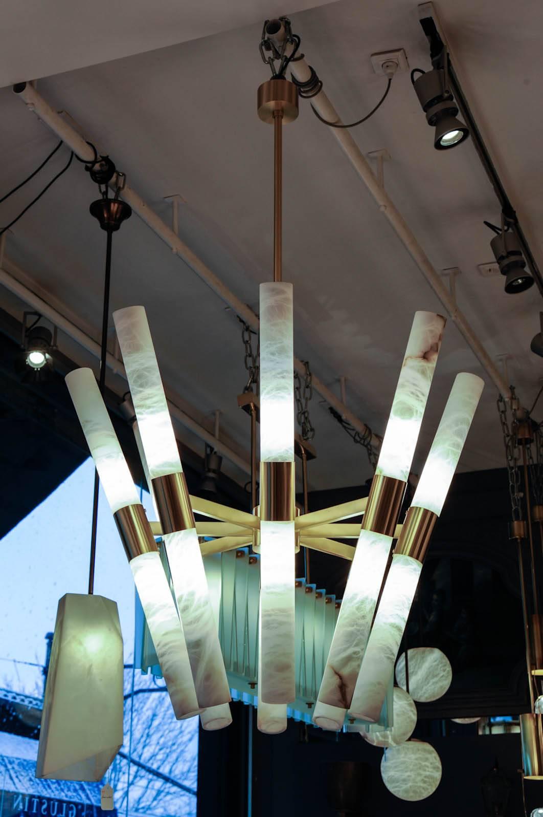 New design by Glustin Luminaires, chandelier made of satin brass chandelier and 16 alabaster rods.

Handmade in Italy by our craftsmen, this chandelier has it's alabaster supports tilted which gather them at the bottom and spread at the top.