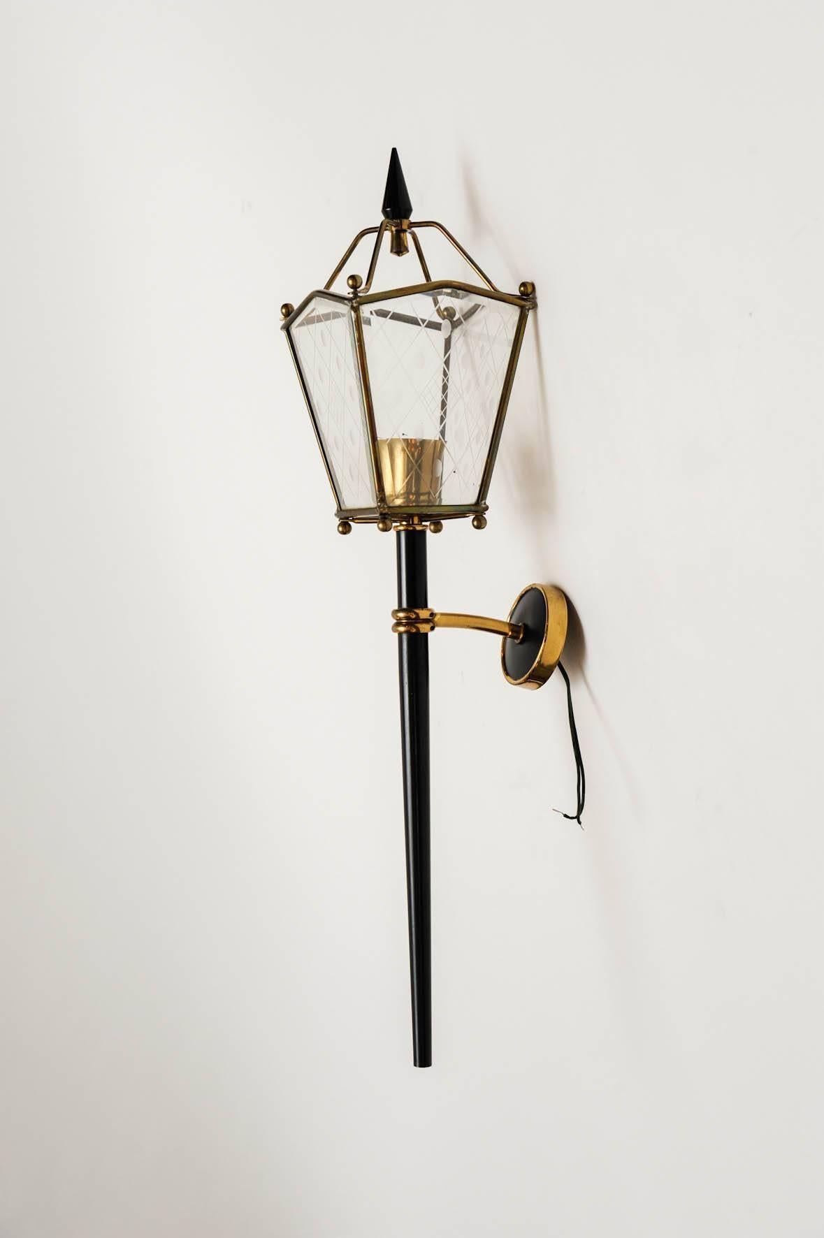 Pair of nice lantern shaped wall sconces made of black painted metal, brass details and glass panels with engraved decors.