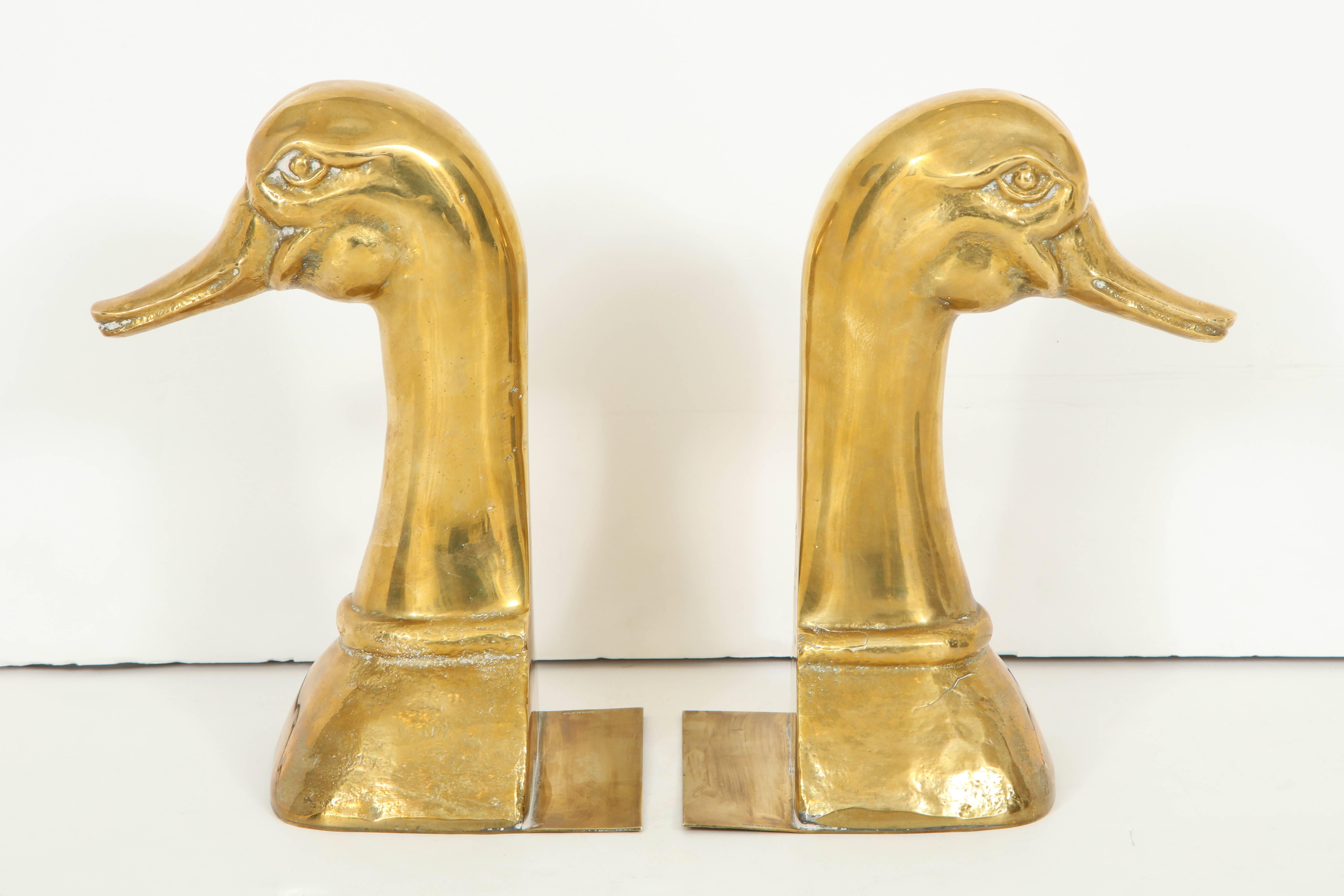 Pair of Duck bookends by Sarreid.
The hefty polished brass duck heads have a beautiful patina to them; they each have a thin plinth which slides under the ends of the books.
