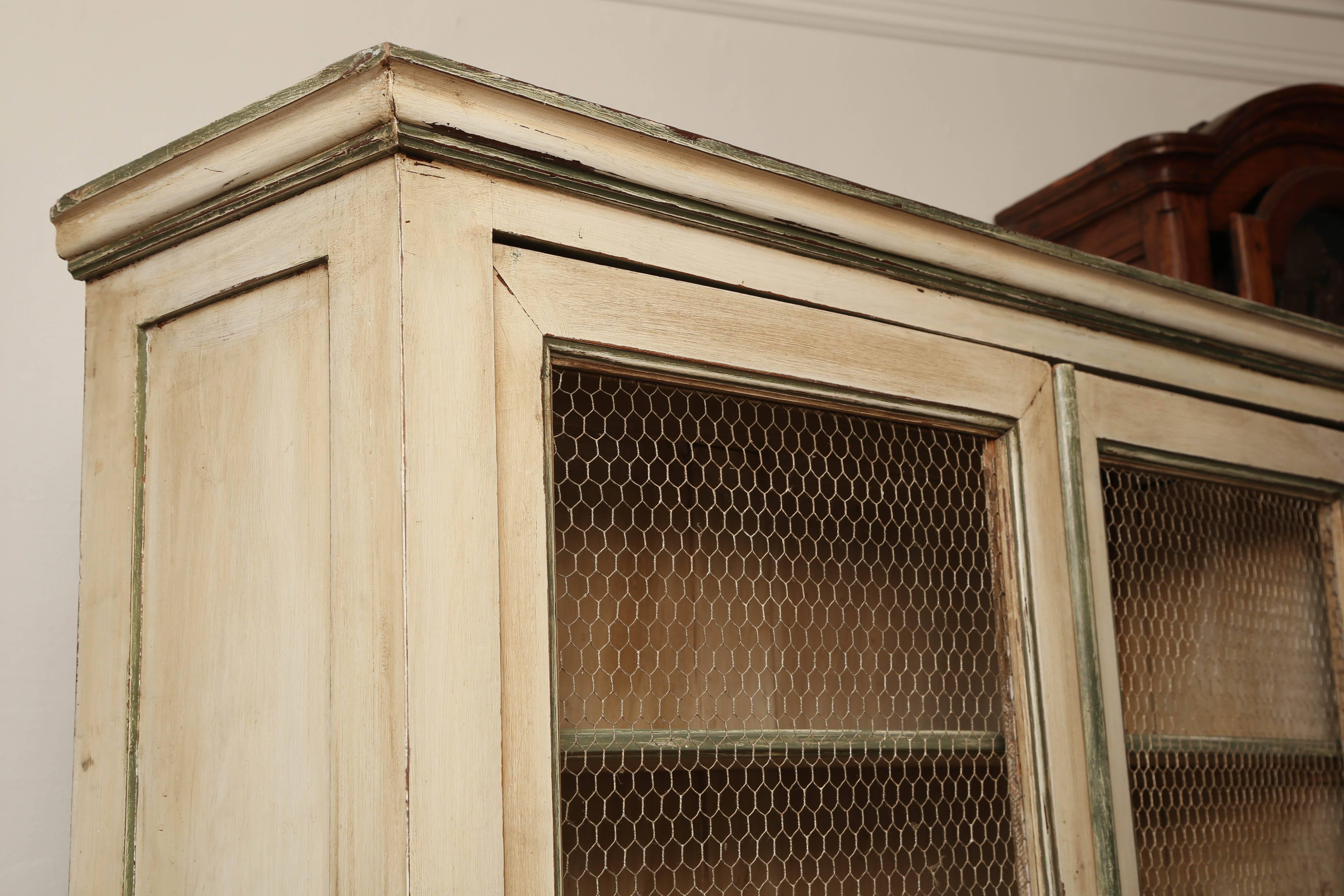 This is a very nice hand-painted bookcase or could be a kitchen cupboard.
It has all the original paint with shelves to the inside.
To the top doors it has chicken wire with a panel below.
Made in France, circa 1890
Measurements are 84 tall 40