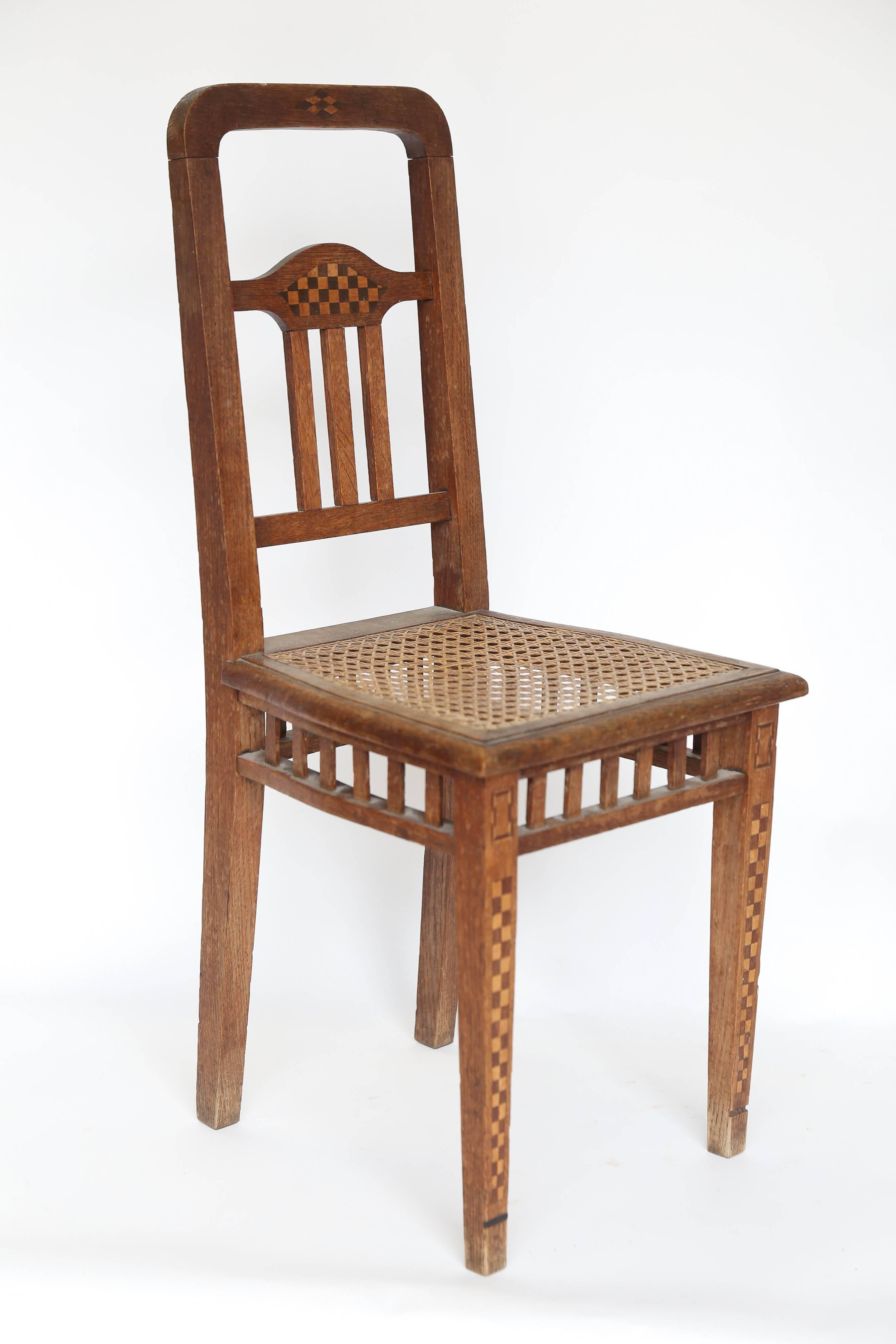 Found in the South of France, a pair of children's chairs with cane seats and intricate inlay. The inlay of light and dark woods enhancing the legs and back make these chairs exceptional. One small inlay is missing from the bottom of a leg. Sturdy,