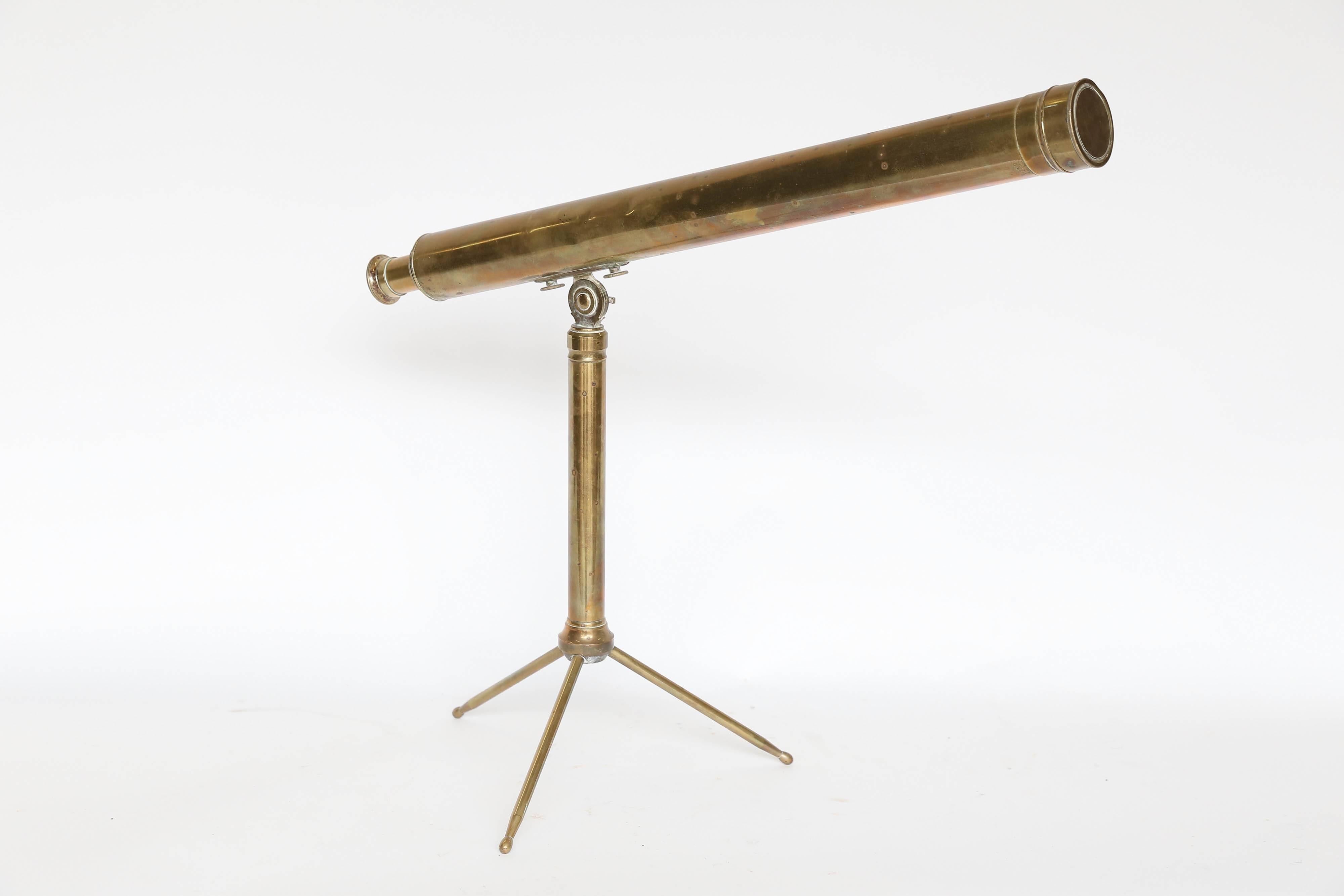 From France, a vintage tabletop telescope made of brass. Standing on a 13-inch tripod stand and rising to 19 inches, the scope is 2.38 inches in diameter and adjusts in length from 25-33 inches. The lens cover is intact and the optics are stable