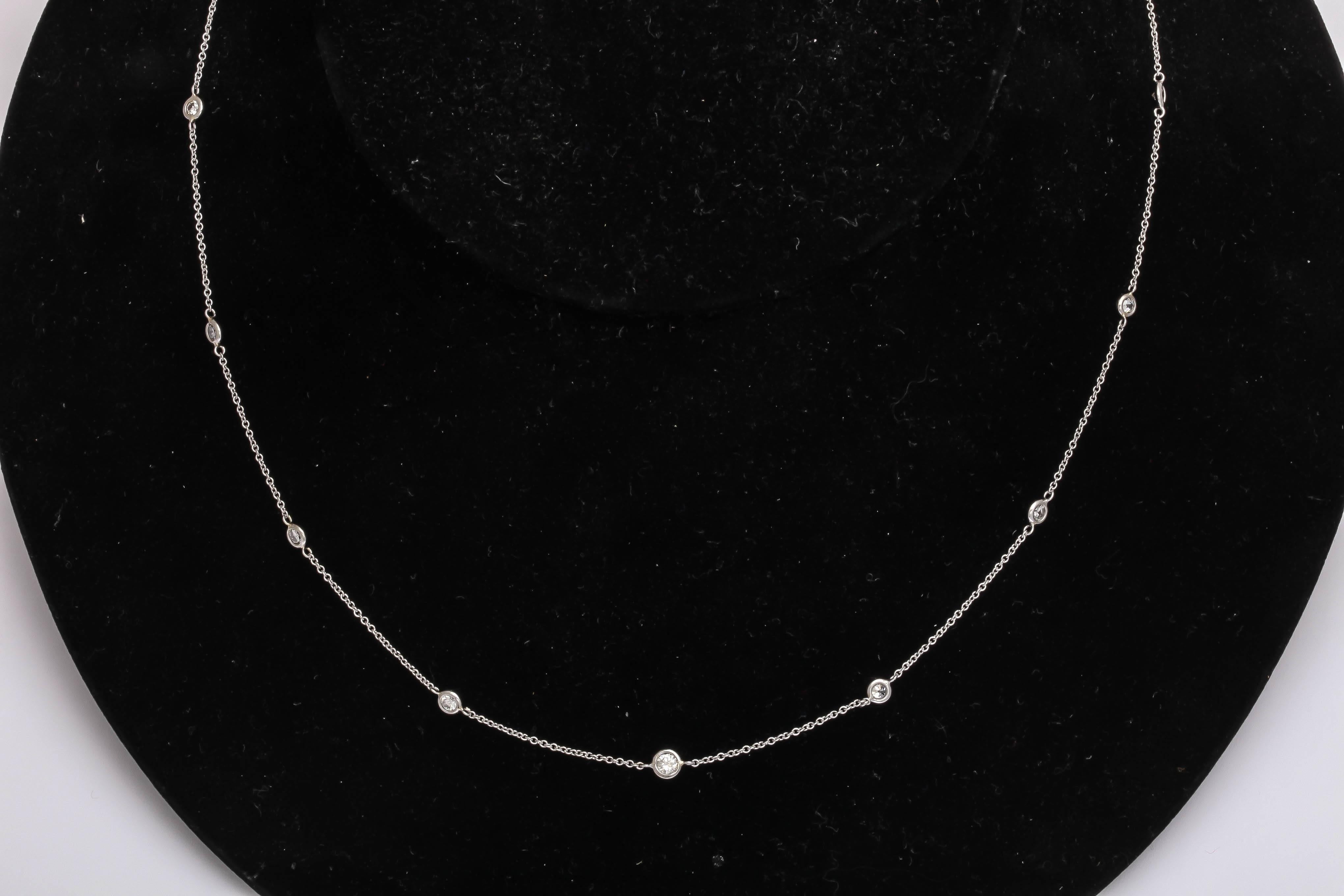 This necklace has 15 white diamonds , bezel set, in a platinum chain measuring about 19.5 in. total. It can be lengthened or shortened. Great for casual wear by itself or worn with a pendant.