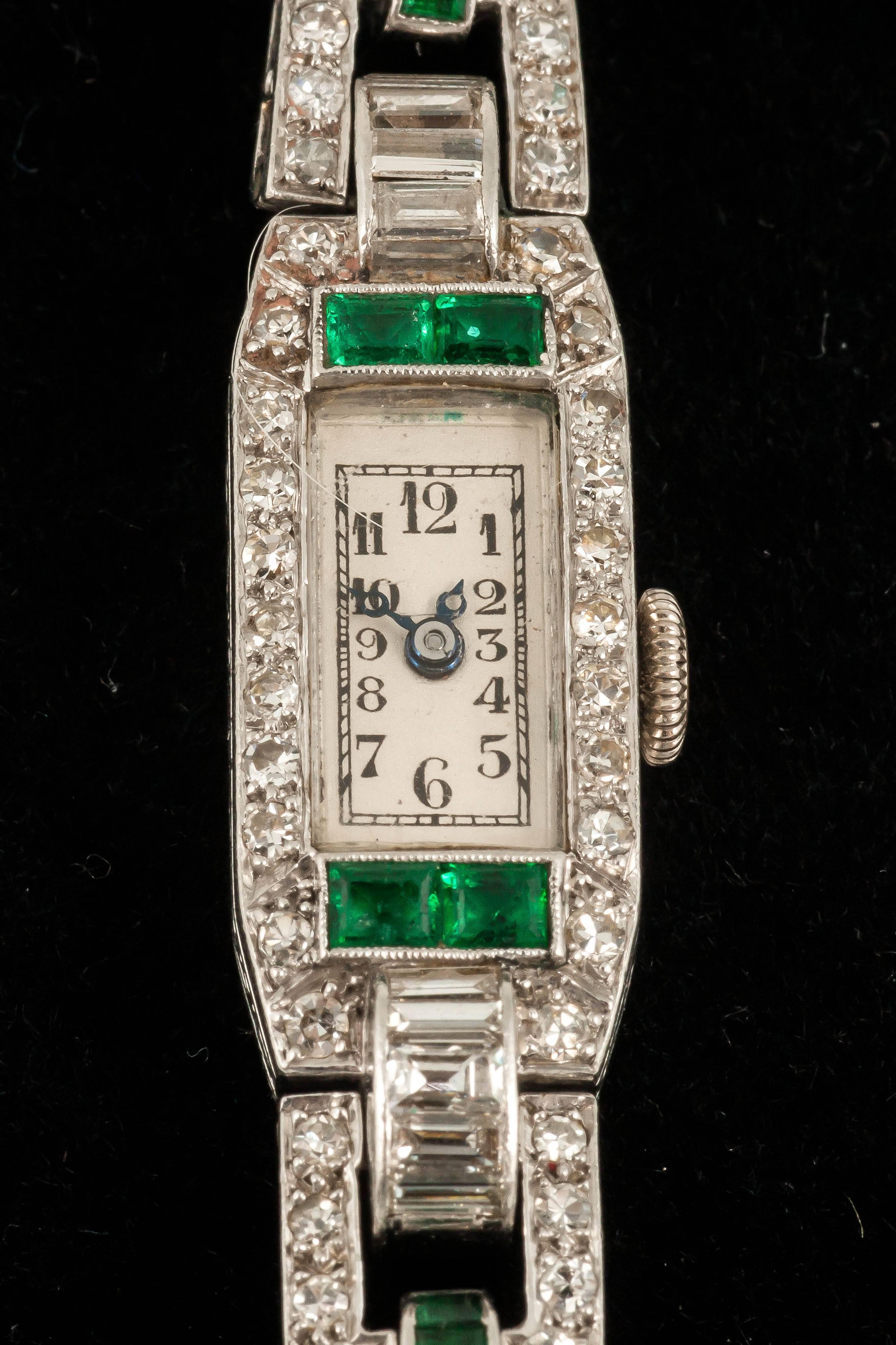 A platinum mounted ladies evening wrist watch set with brilliant diamonds and emeralds in Art Deco period c,1930,with original corded bracelet,hand wound jewelled movement