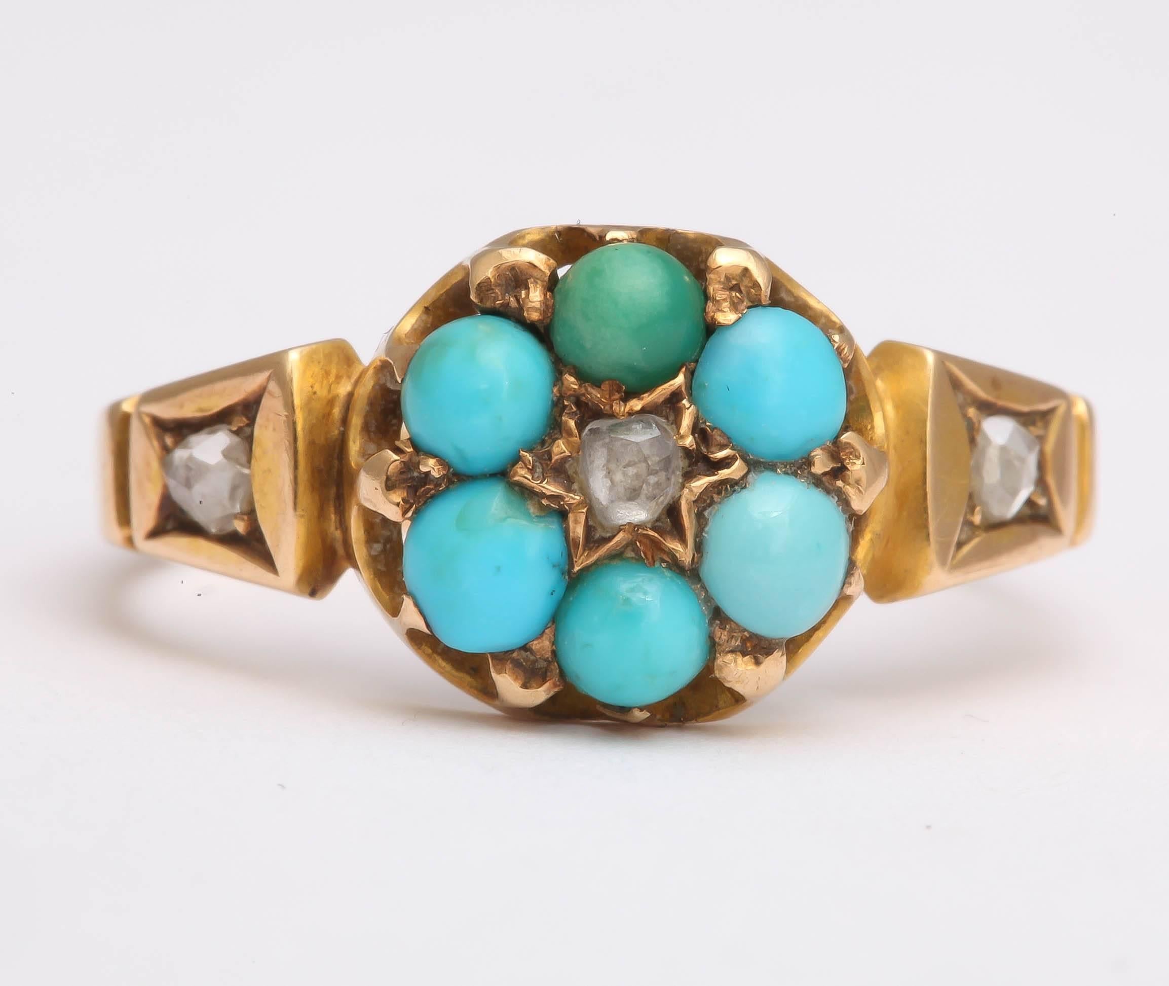 The lovely Victorian ring is a turquoise cluster consisting of six cabochon stones surrounding a rose cut diamond set in a star design. Each shoulder is also set with a rose cut diamond. The ring is English, 15K, and has hallmarks in the interior of