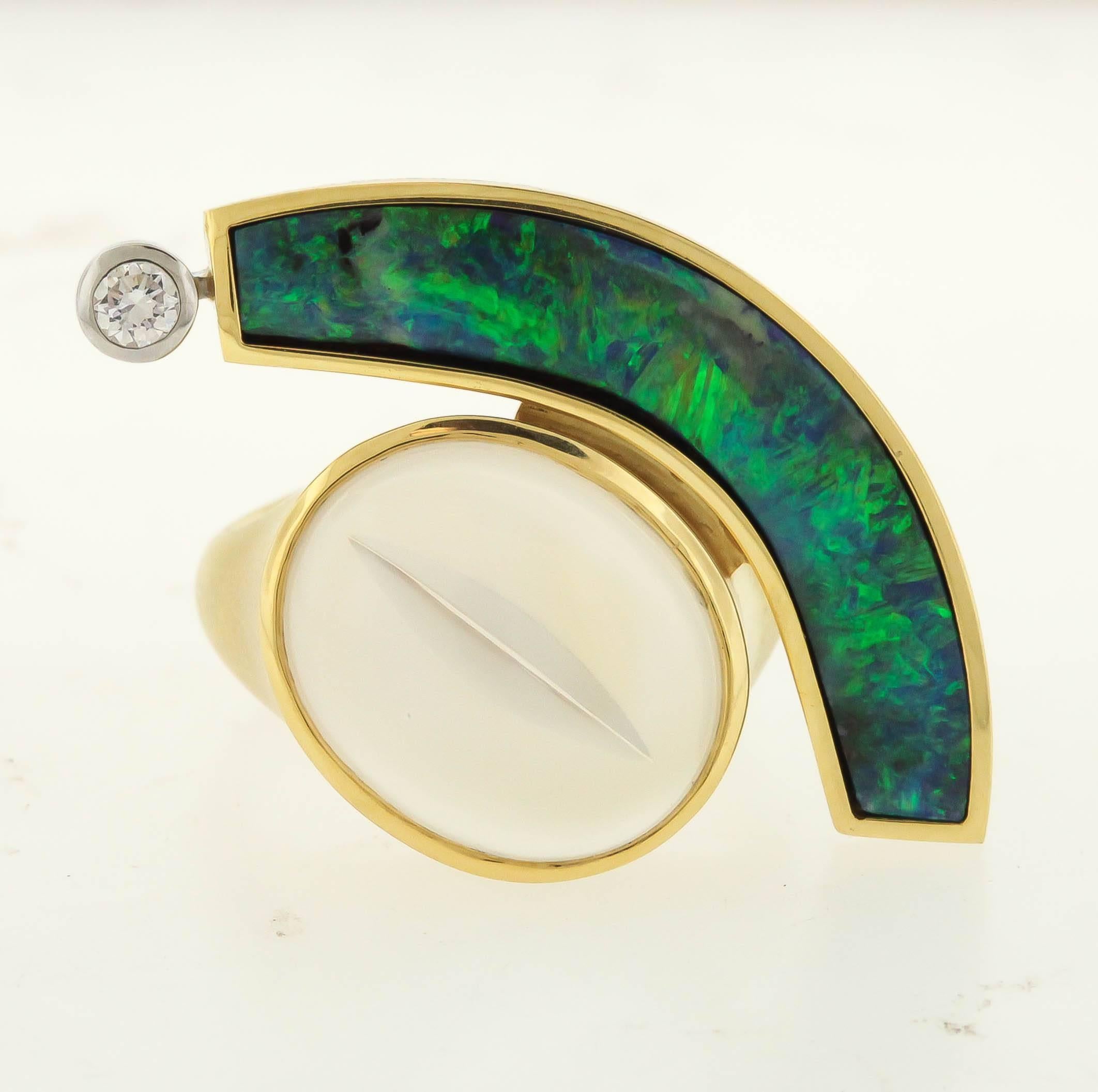 Magnificent boulder opal, 4.68 carats, is cut in a crescent that wraps around a luminous moonstone with a cat's eye facet by Tom Munsteiner, accented in the 18K gold mounting with an 0.08 ct. diamond.  The ring measures 1