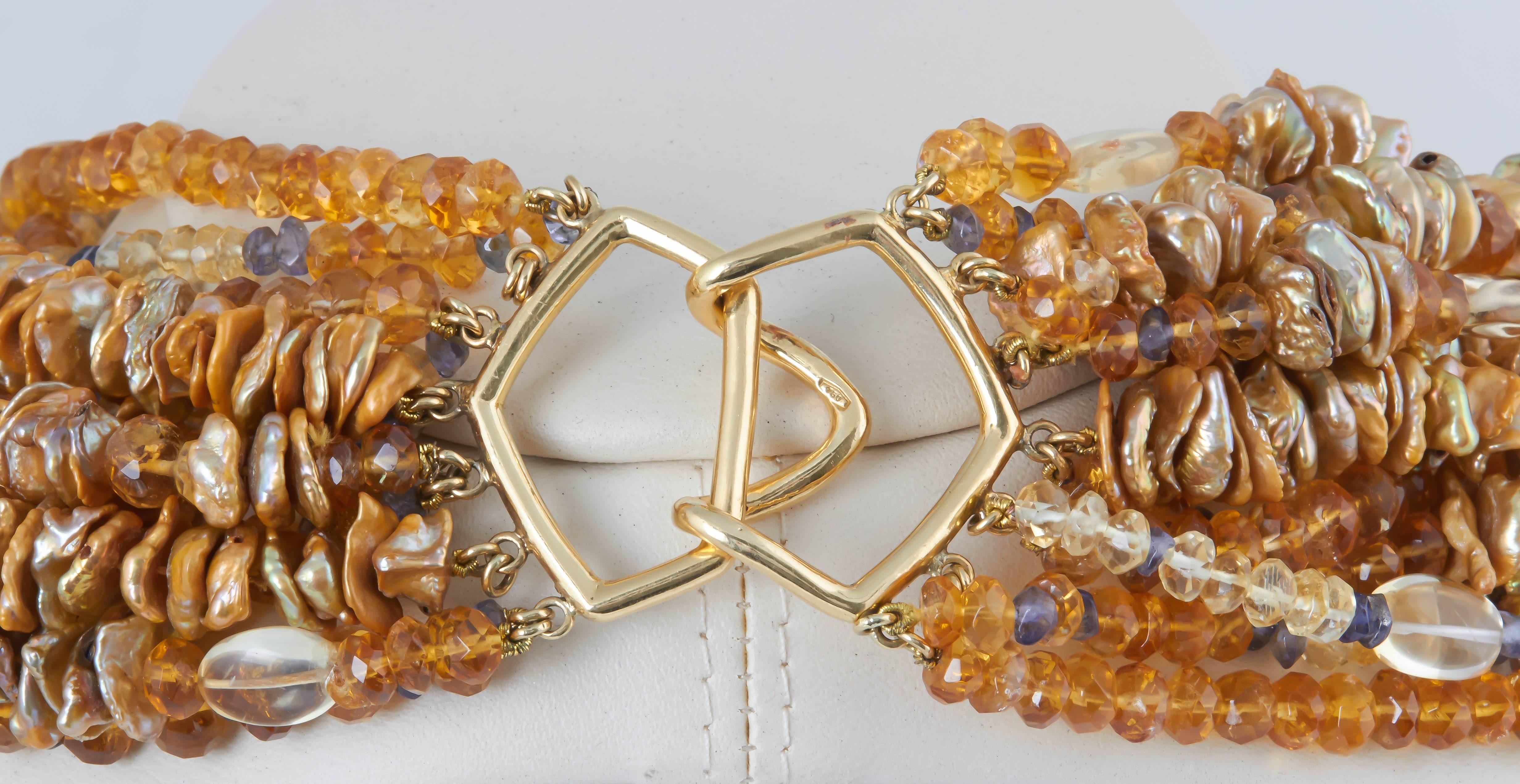Twelve strands of golden color keshi pearls drilled through the center interspersed with strands of faceted citrine and sapphire beads. The necklace is finished with a large 18 kt clasp. The shortest stand is 18 in. and the longest about 22 in.