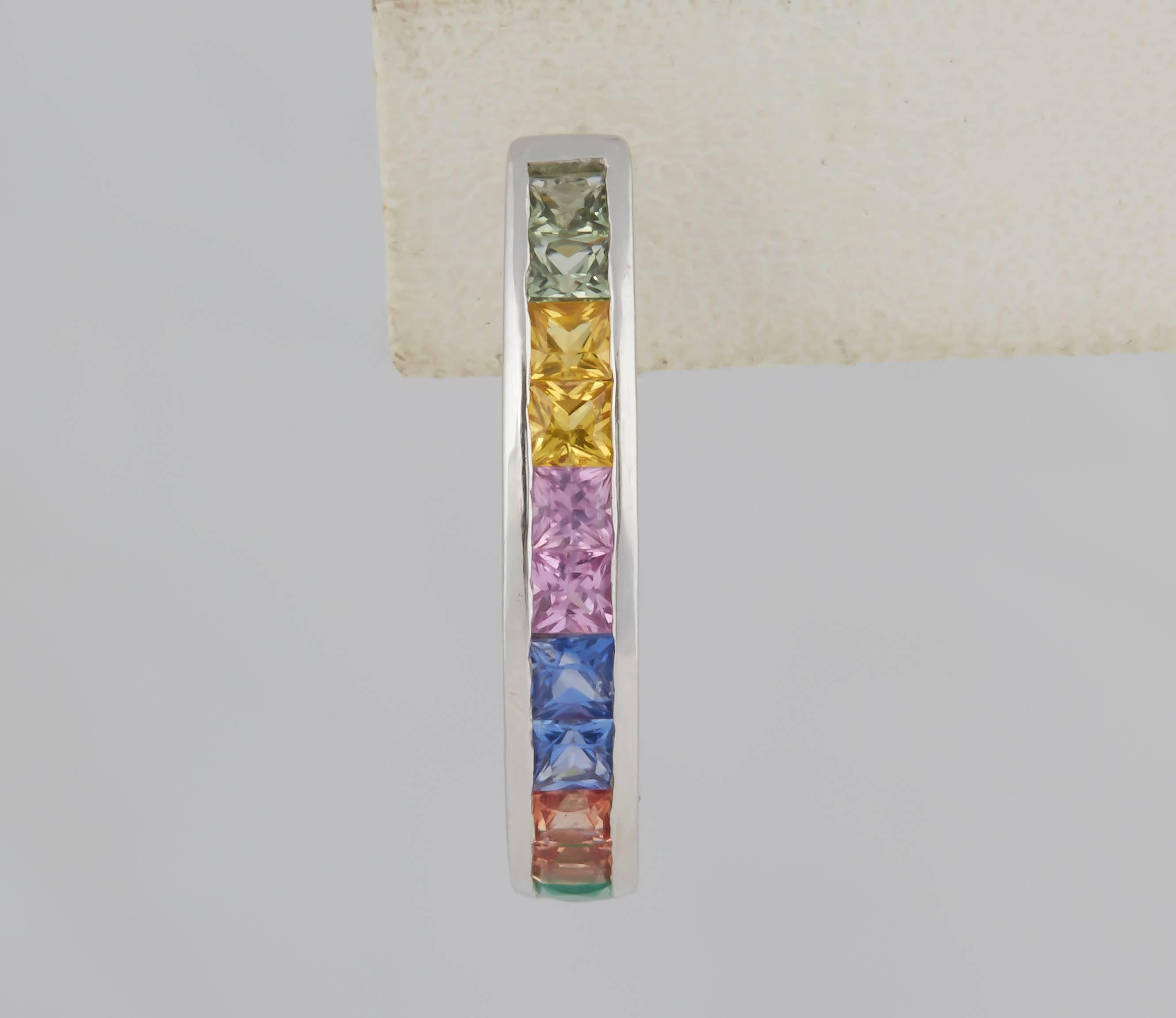 Great looking hoops with green, yellow, pink blue, orange sapphires with the last stone, a green emerald. The square stones are French (or scissor cut) given them extra flash. They are channel set in 14 kt white gold for a sleek and modern look. The