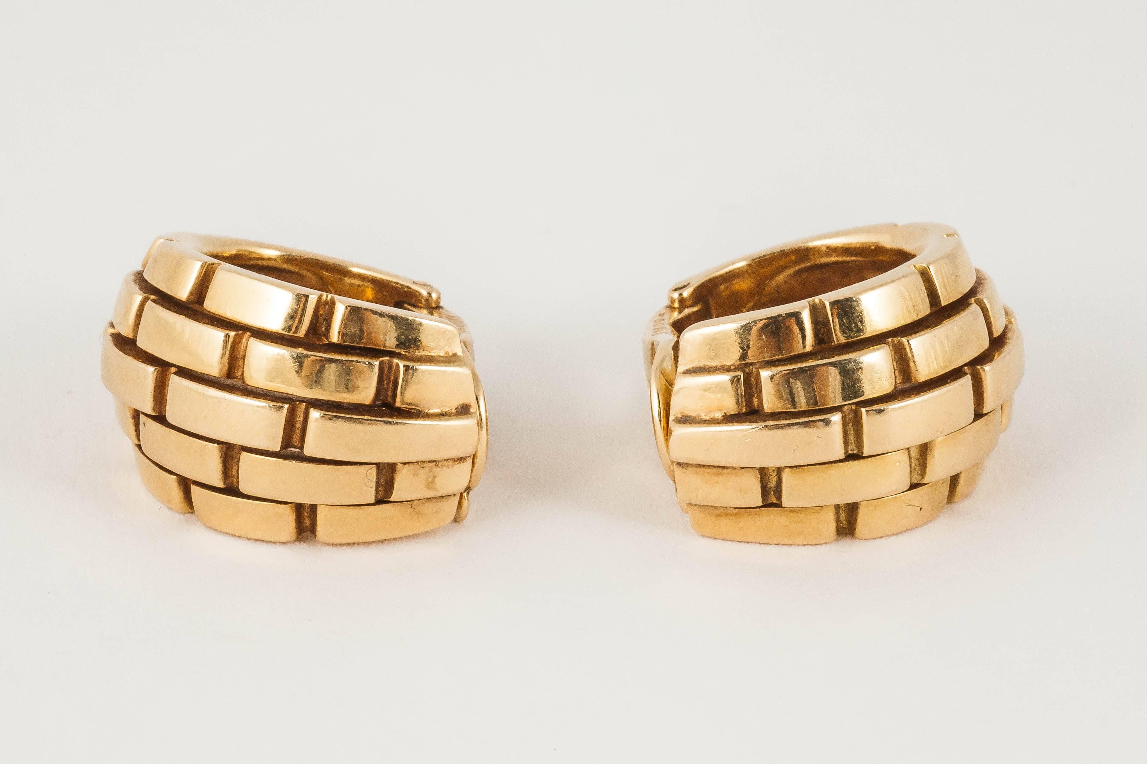 A heavy pair of 18ct yellow gold wide creole shaped earrings with French marks,Signed Cartier and numbered 616094.c,1960
