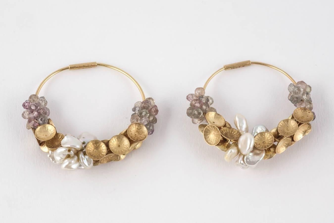 18ct Matt Gold Donna Brennan Hoop Earrings. Enchantedly encrusted with Sapphires, Freshwater Pearls & gold disks, these elegant earrings evoke the timeless appeal of Antiquity.

Donna's work typically features jewellery & sculpturally wrapped