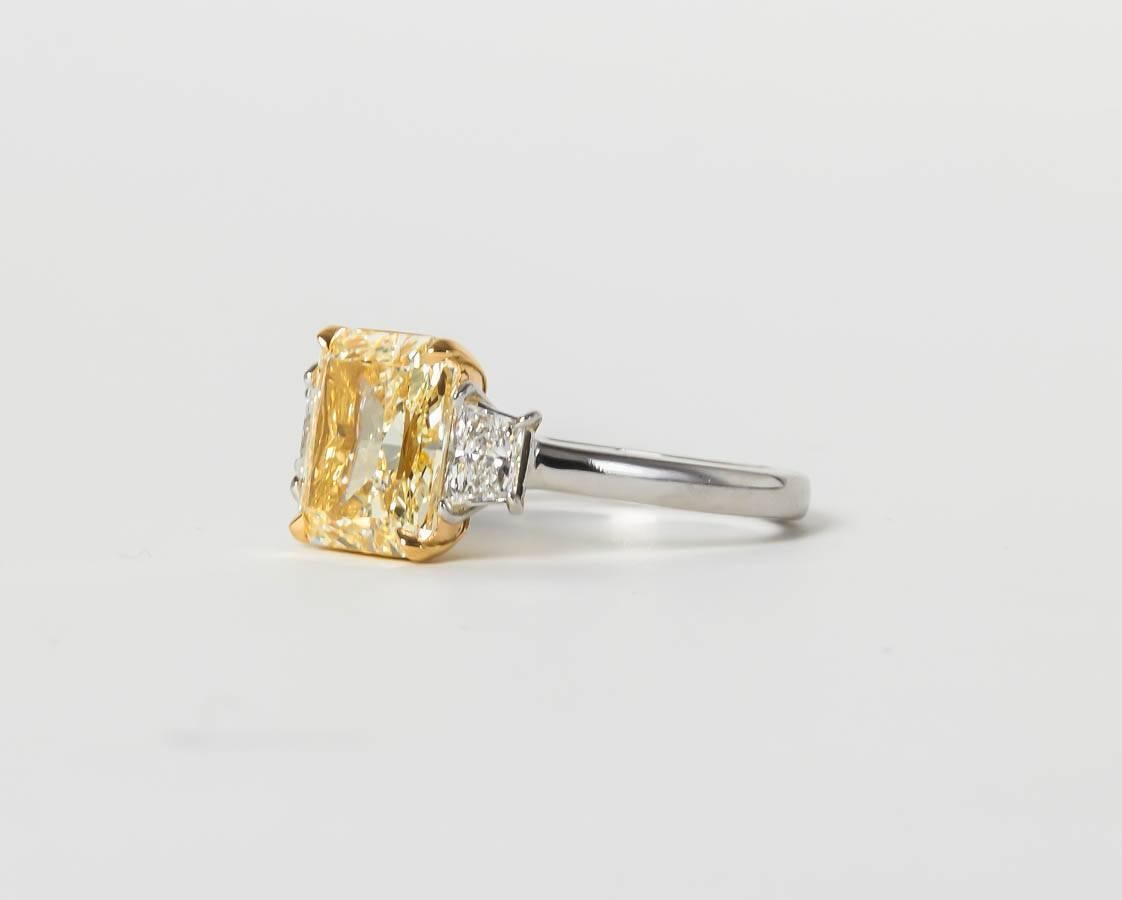 An incredibly brilliant yellow diamond with a deep yellow color.

GIA 4.01 Fancy Light Yellow center diamond, VS1 clarity set with .42 carats of trapezoid cut white diamonds.

Custom made in platinum.