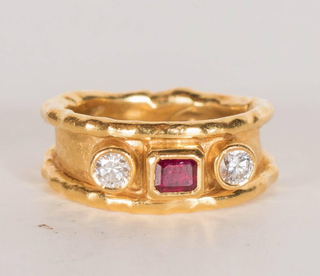 This stunning ring is Hand made sophisticated stylish  created by Jean Mahie in the 1970's. Made of 22k yellow gold set with two diamonds approximately ½ carat also set with a center emerald cut ruby of fine quality. Hand-made, one-of-a kind and