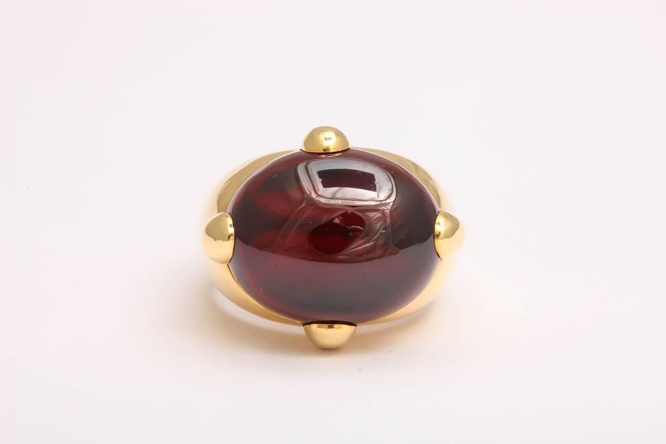 18kt yellow gold high style large cabochon garnet ring centering a 20 carat cabochon garnet which is set in a super strong and thick four prong setting for extra security and beautiful design effect. Signed by Pomellato Italy designed in the 1980's