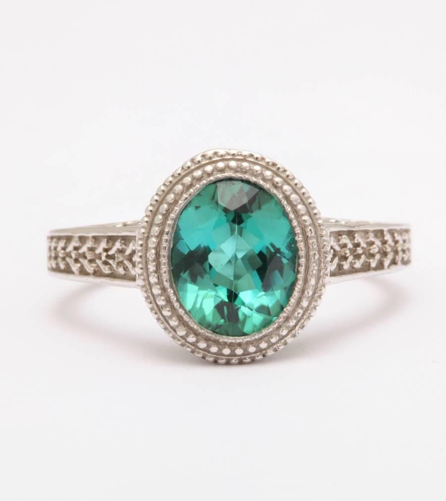 This classically engraved 14 kt ring has an 7 X 9 mm tourmaline in a gorgeous light teal color,beautifully faceted in an oval shape. This is a very rare color in tourmaline and was mined and cut in Brazil. The ring is a size 7 and can be sized at