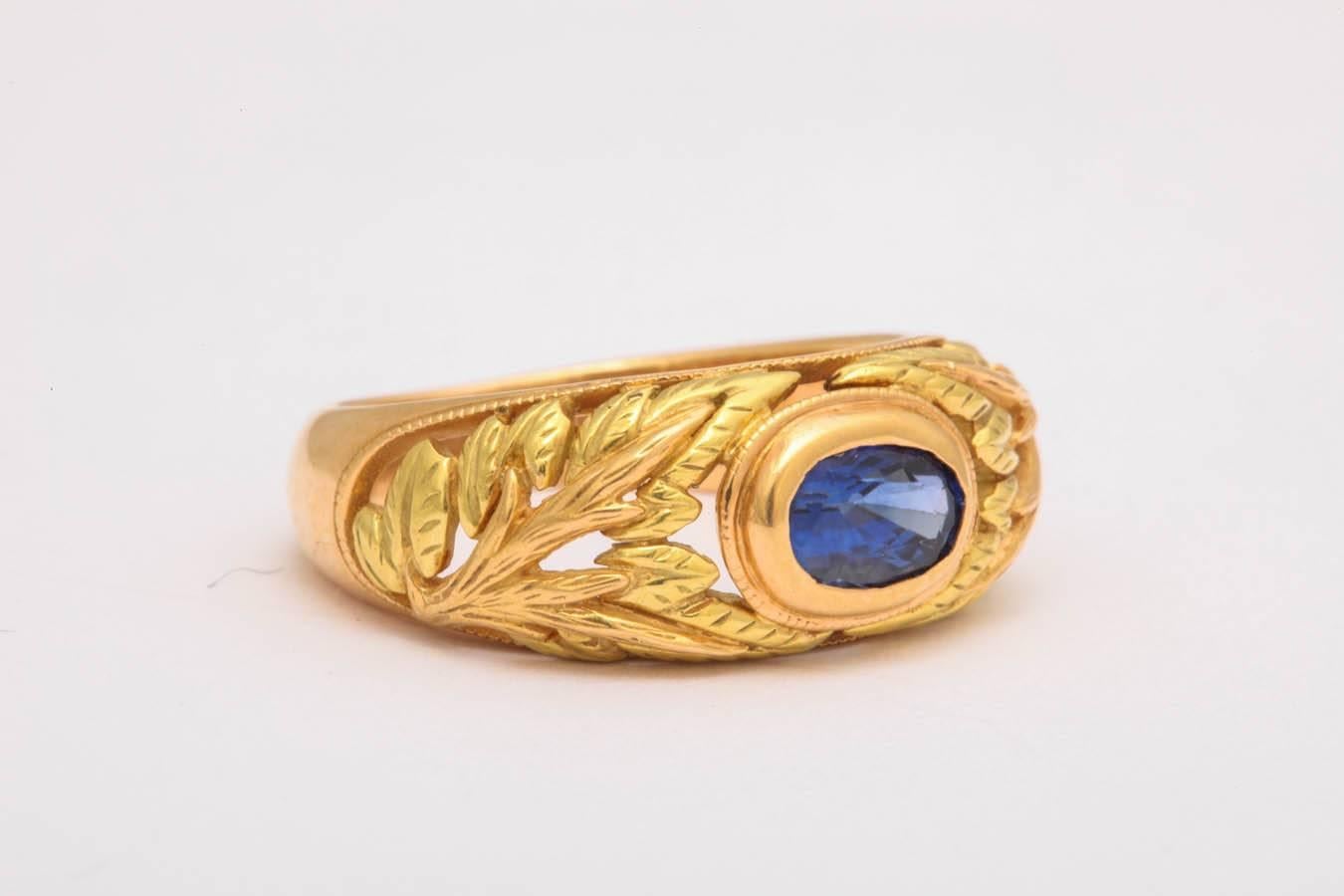The combination of pink and yellow gold is carved in a lacey leaf pattern. The center faceted oval blue sapphire is 5 X 7 mm and 1.2 cts. The center stone can be changed at your request.