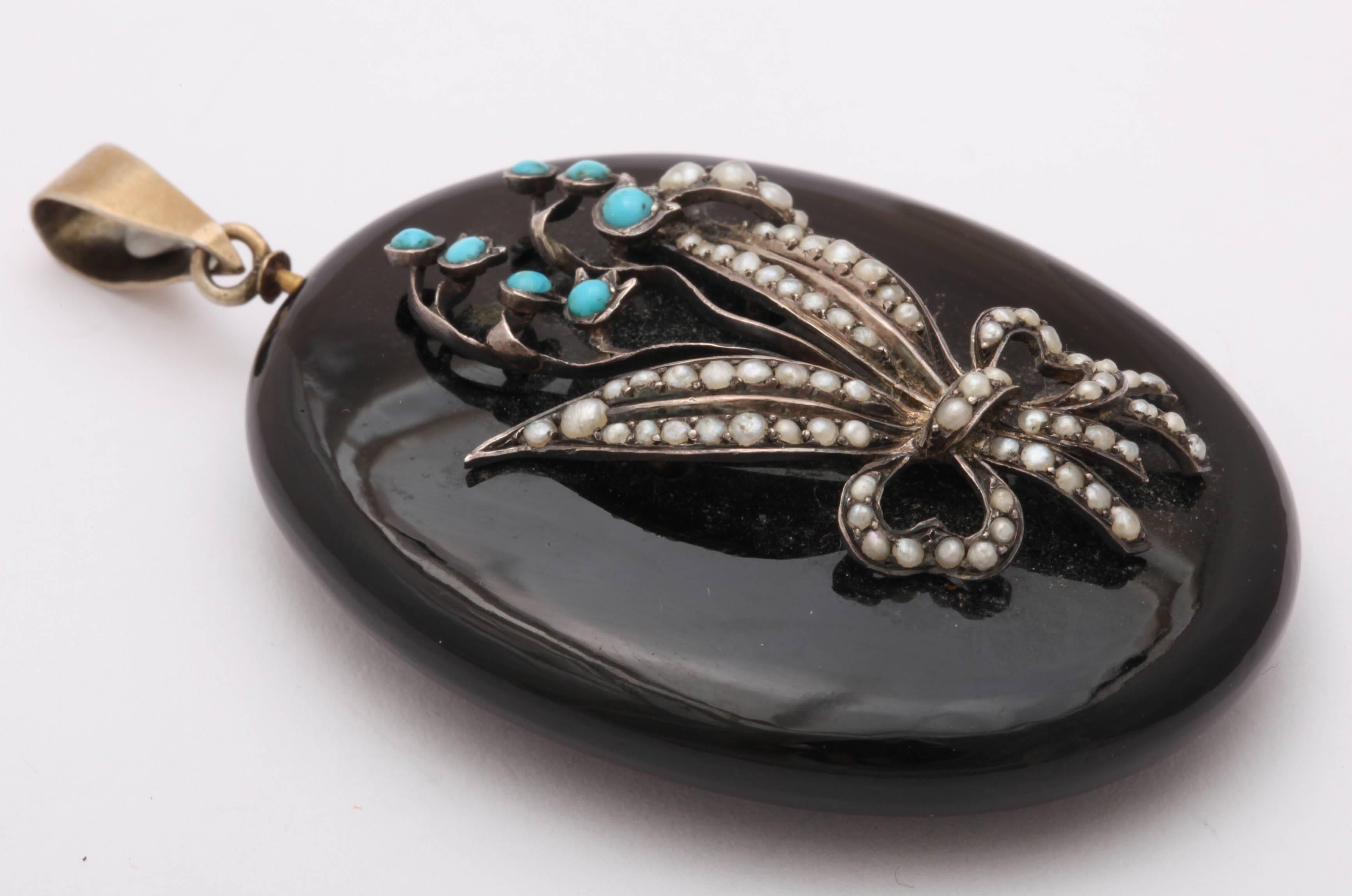 Victorian Turquoise, Natural Pearl, and Enamel Lily of the Valley Locket Victorian turquoise and natural pearl enamel locket was made c. 1860 in England. The top layer shows a large spray of turquoise and pearl Lily of the Valley. All gems are