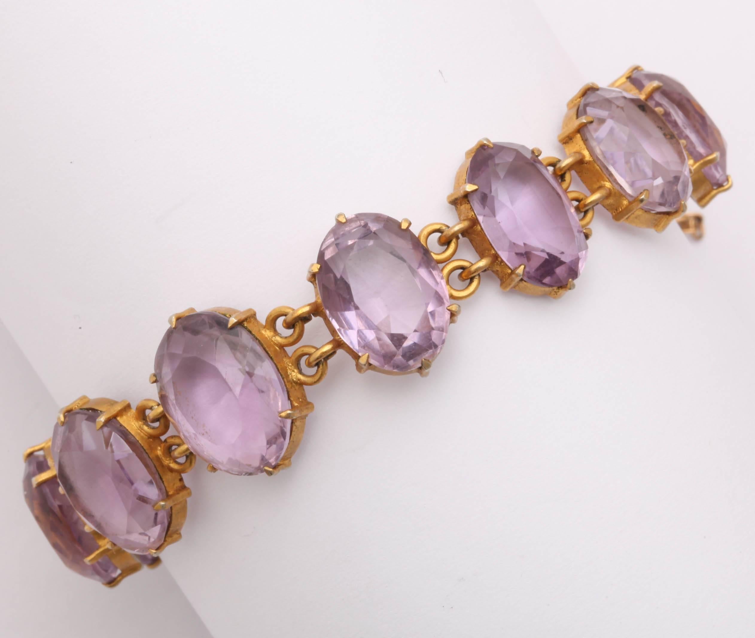 Ein Armband aus klaren, ovalen Amethysten von je etwa 5 Karat, gefasst in
vermeil-Zierzacken. Vermeil ist Gold auf Silber. Die Amethyste sind stark lichtreflektierend, haben eine flache, erhöhte Tafel, sind hinten spitz facettiert und vorne rund um