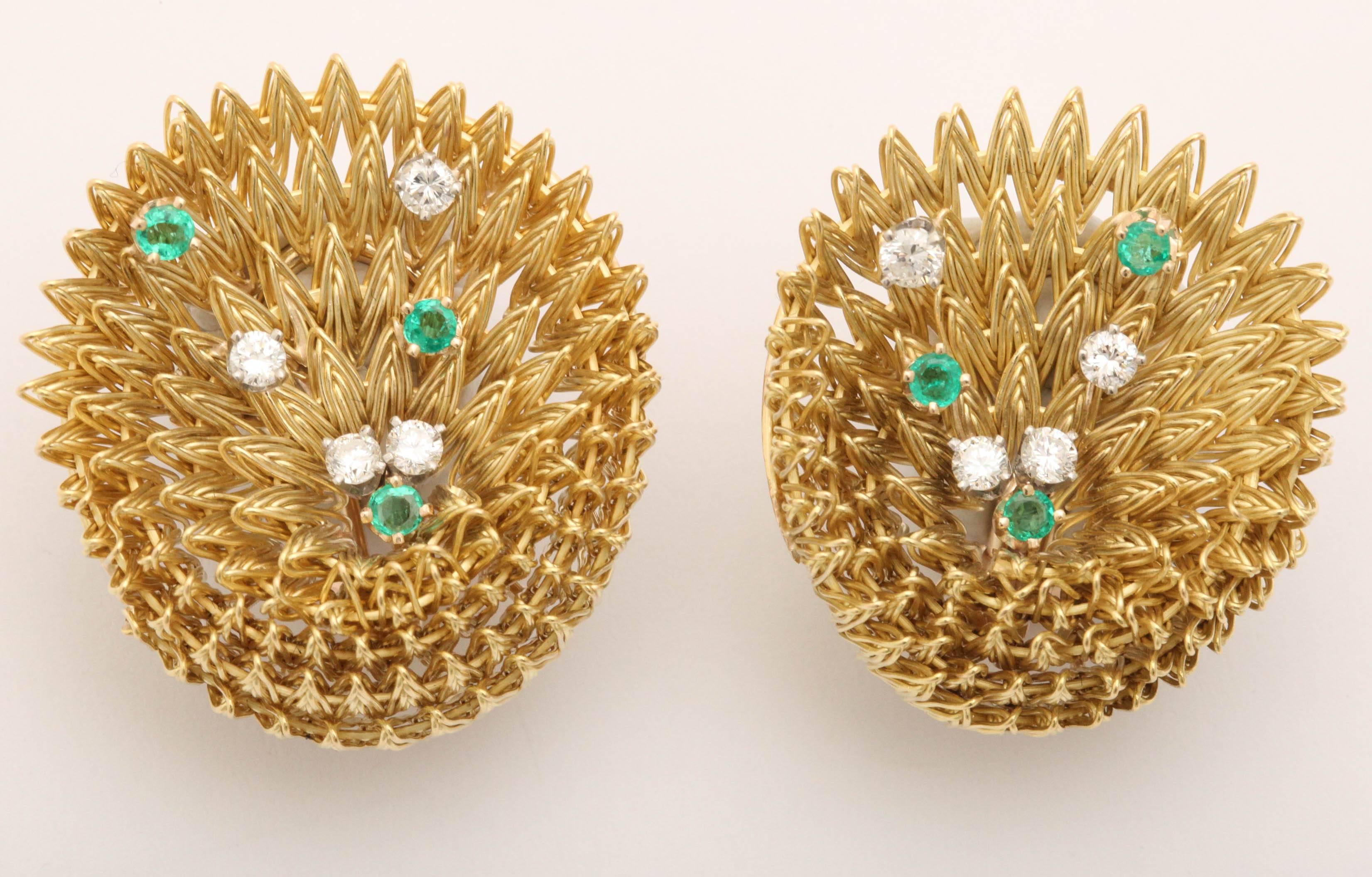 Pair  of 18kt Yellow Gold woven and intertwined Earring Set - with Omega Backs - complemented by matching Pin. Signed L in a Triangle  but unknown maker.
Sprinkled with asymmetric f Prong set Emeralds and Diamonds. 