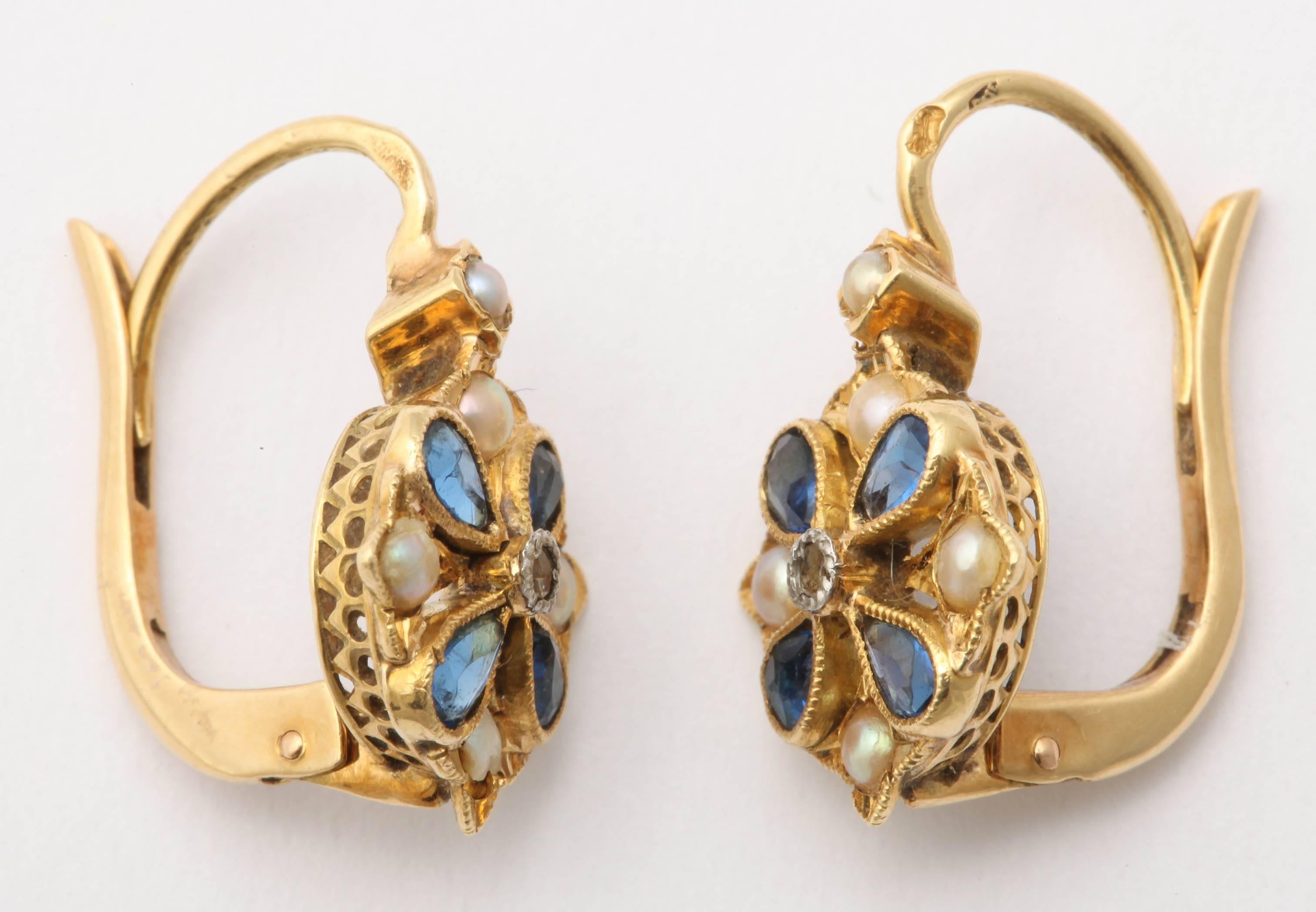 These sweet French earrings alternate marquise cut sapphires and seed pearls in a floral pattern around rose cut diamond centers. Set in 18K gold with lever backs.