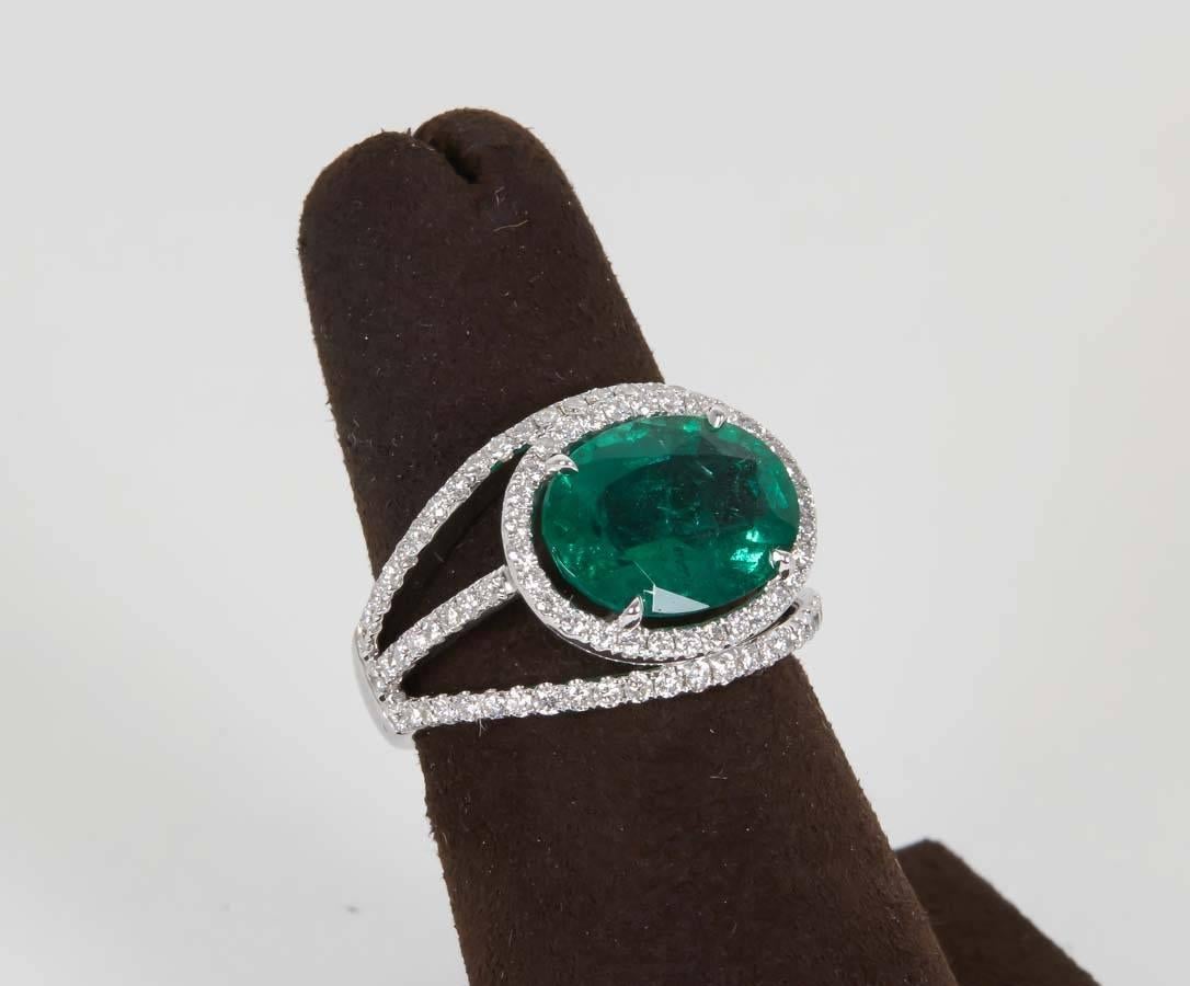 
3.68 carat oval shaped Green Emerald set horizontally in a dome style micro set unique diamond mounting. 

1.10 cts of white brilliant cut diamonds

18k

A fabulous and unique ring!
