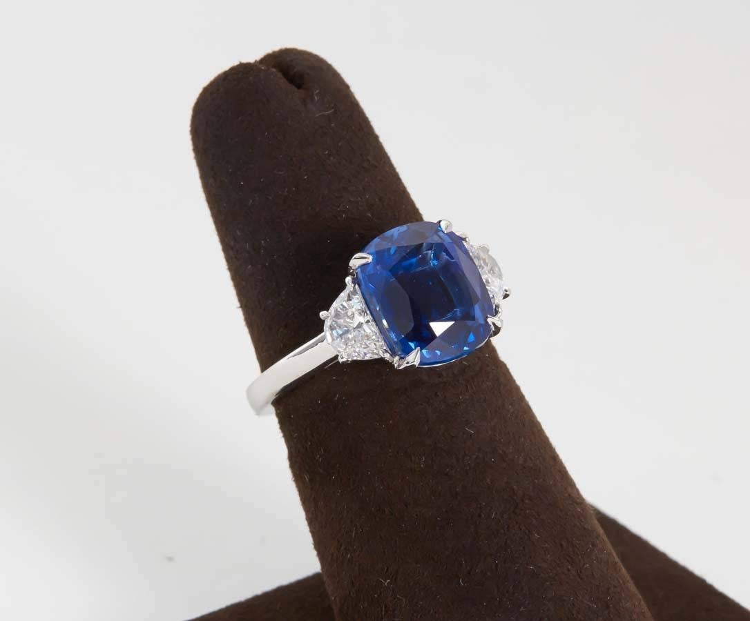 
A beautiful sapphire and diamond ring! The perfect size, color and shape!

5.54 carat cushion cut vivid blue sapphire.

0.43 carats of white side diamonds, custom platinum mounting.

The sapphire is accompanied by a C. DUNAIGRE of