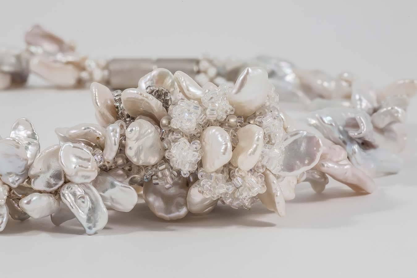 Beguiling cluster of free-form freshwater pearls and Japanese glass seed beads entwine to create a statement neckpiece. Handcrafted by Donna Brennan in her London studio, it is clinched at the nape of the neck with a Sterling Silver