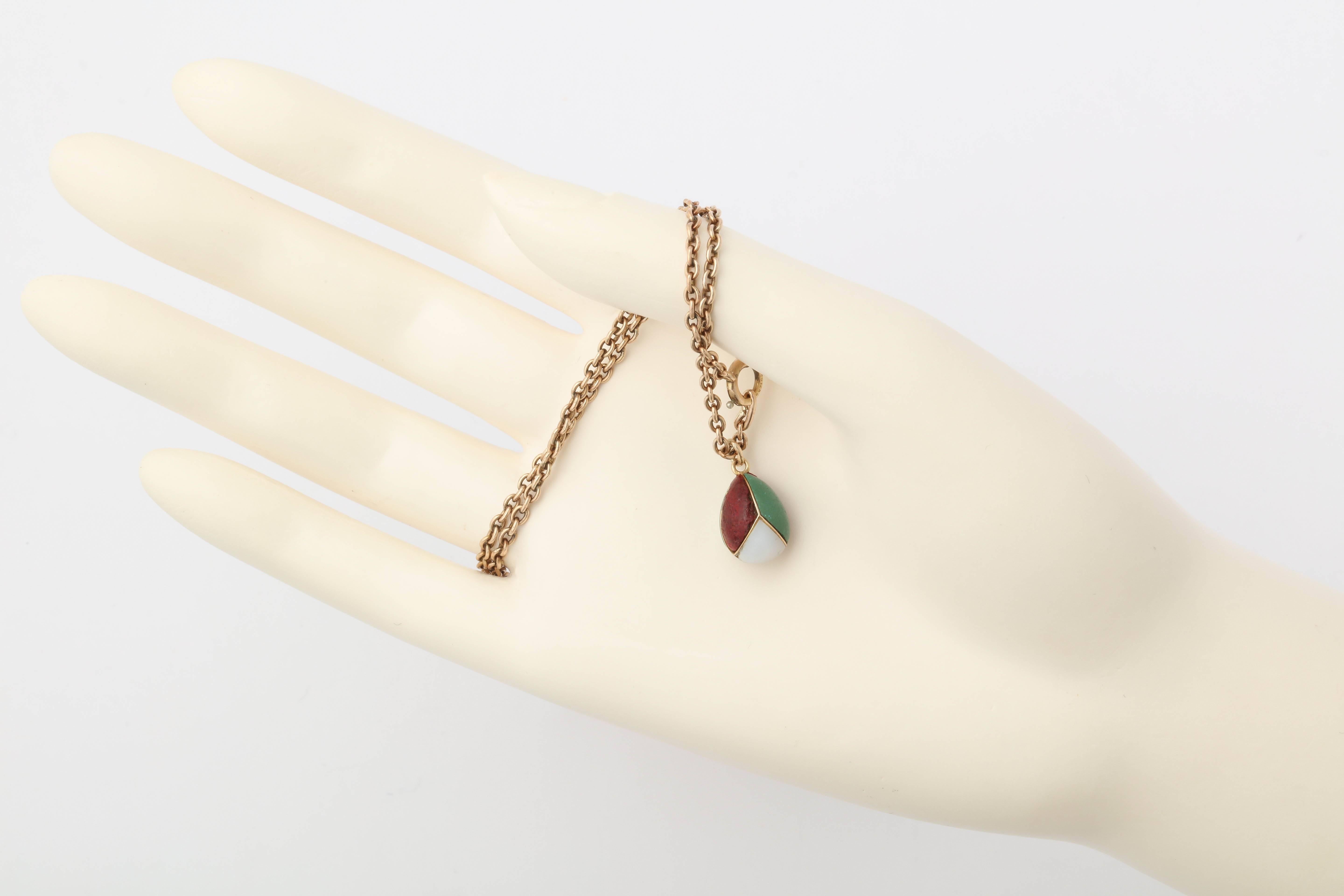 Di epoca Romanov, questo raro uovo russo in miniatura dall'insolito design ad albero è intarsiato con agata bianca, porpora rossa e vetro verde opaco e diviso da bande d'oro, attaccate a un anello di sospensione d'oro.

Russia, circa 1890, timbro