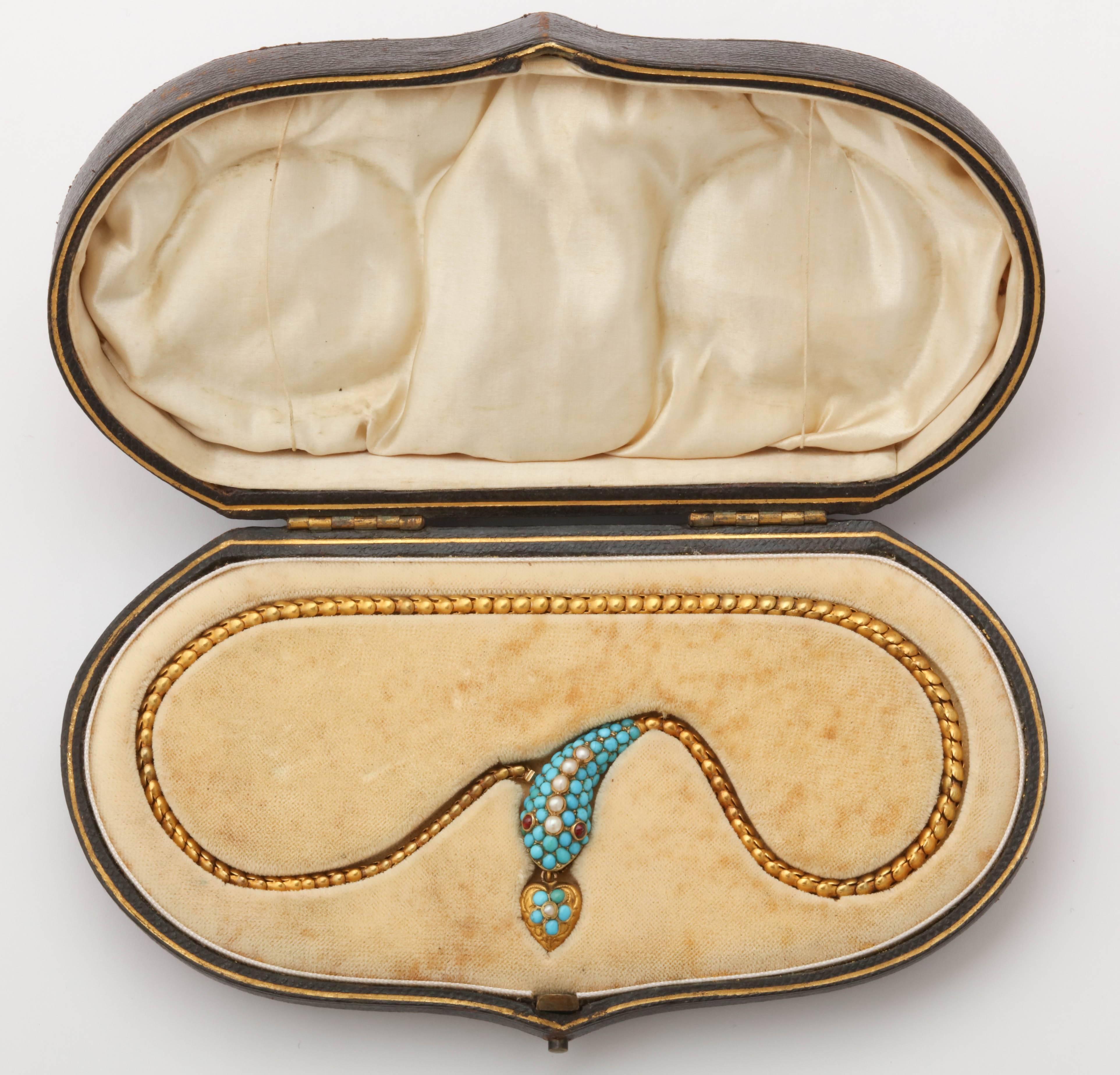 15K gold Victorian necklace adorned with snake's head in turquoise and pearls with garnet eyes. Dangling heart charm has locket compartment in the back. Necklace is accompanied by original fitted box.