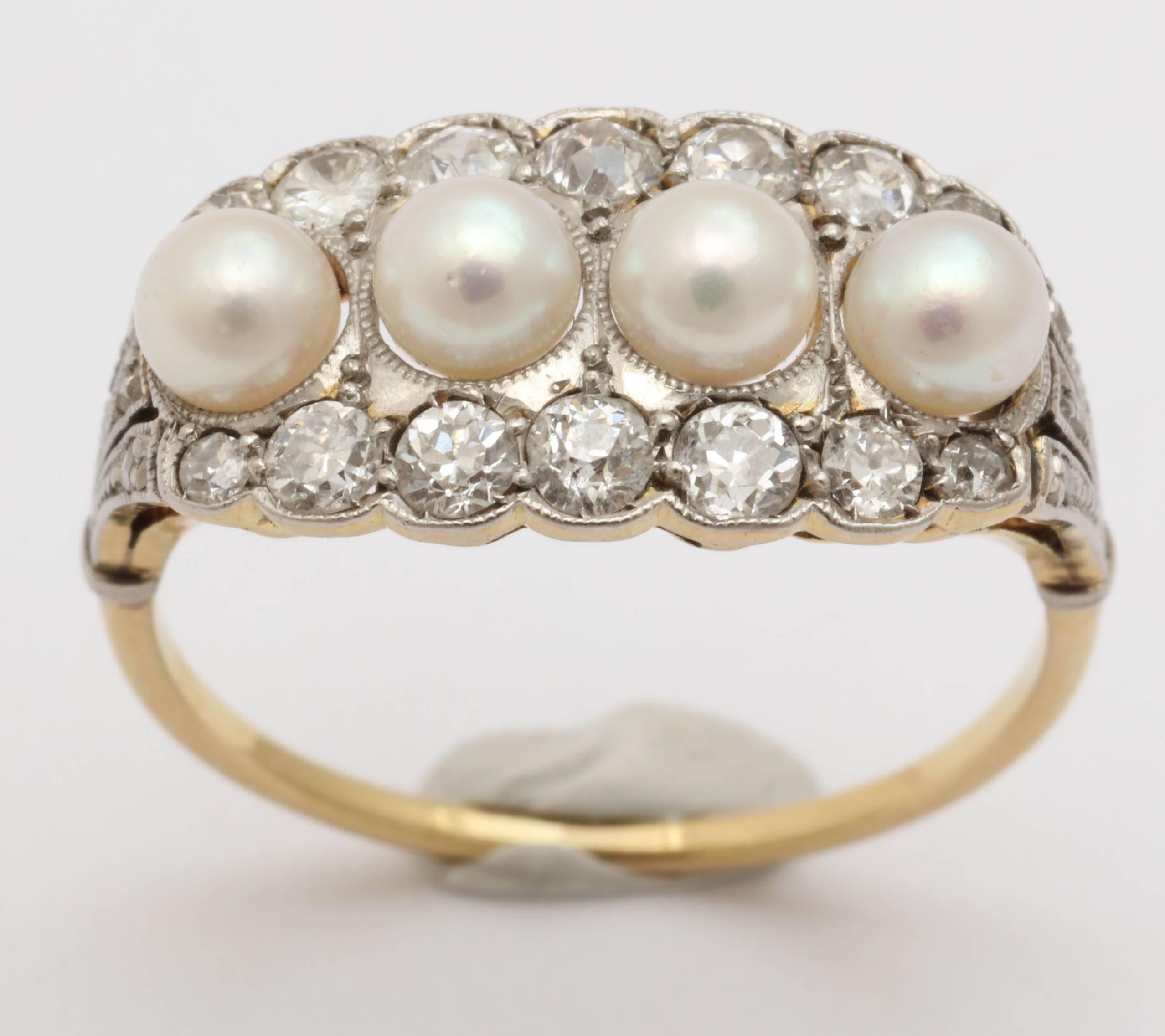 Englischer Ring aus der Edwardianischen Zeit, Platin auf 18 Karat Gelbgold. Mit 4 natürlichen Vollperlen und 20 Diamanten besetzt: 5 Diamanten in der Mitte der Perlenreihe (ca. 0,07 - 0,10 ct), 2 kleinere Diamanten an den Enden der Reihe (ca. 0,02