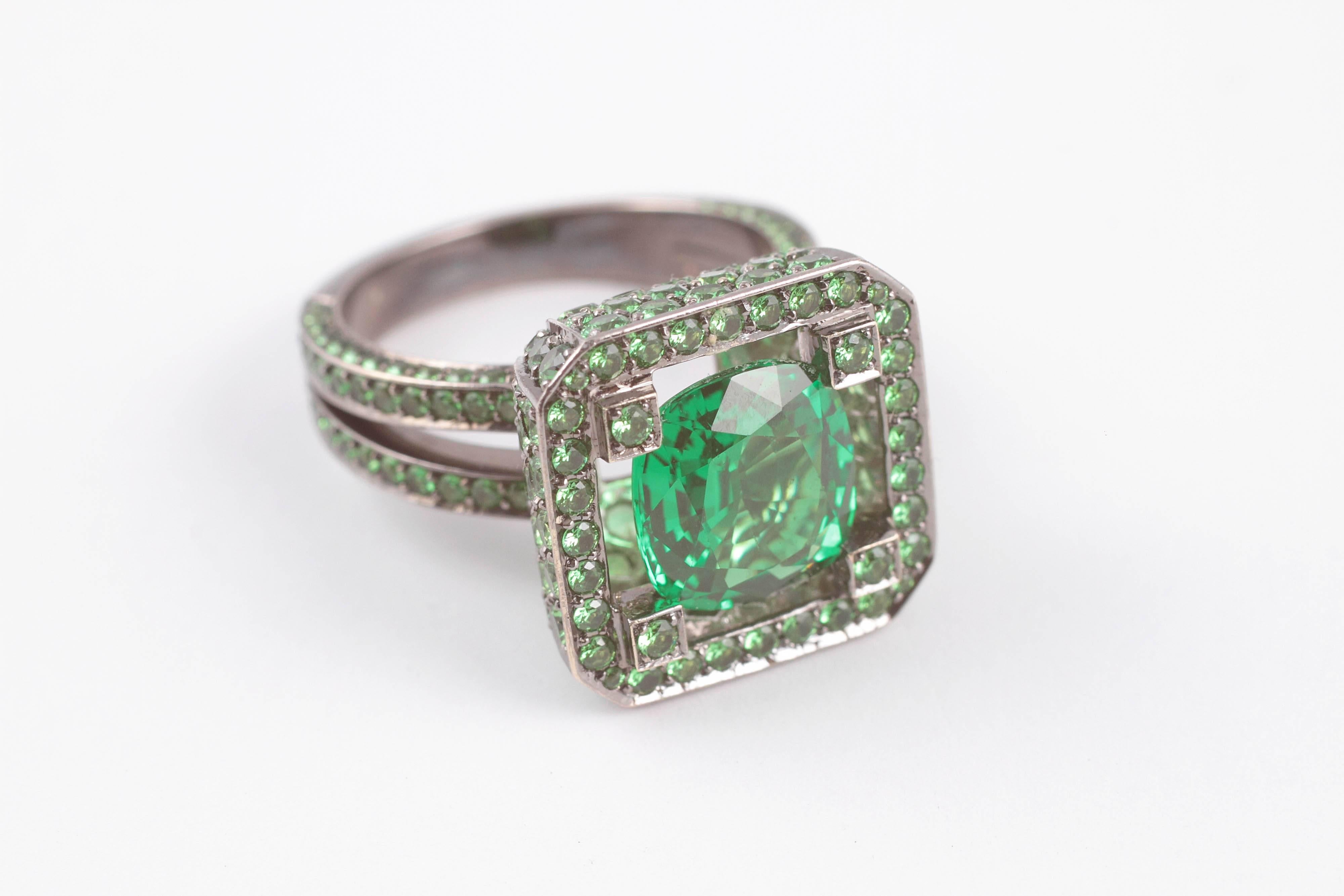 A beautiful, bright green garnet is nested in the middle of more of the same.  For those of you born in January who don't think you have a pretty birthstone, Think again.  This London based designer is making a statement for anyone wants to wear the