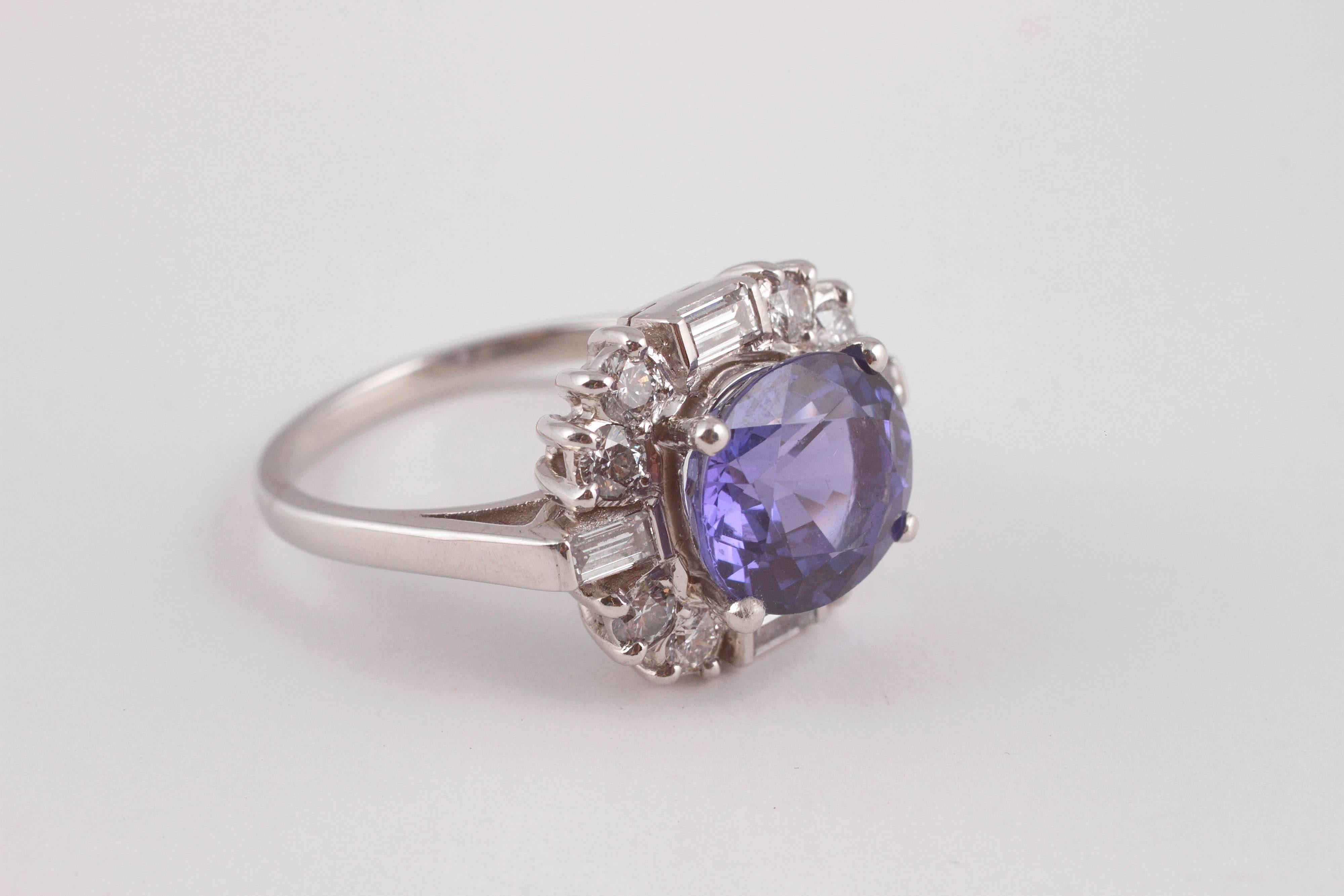 Oval shaped and horizontally set 3.95 ct tanzanite in a vintage platinum and diamond mounting.    Size 8.