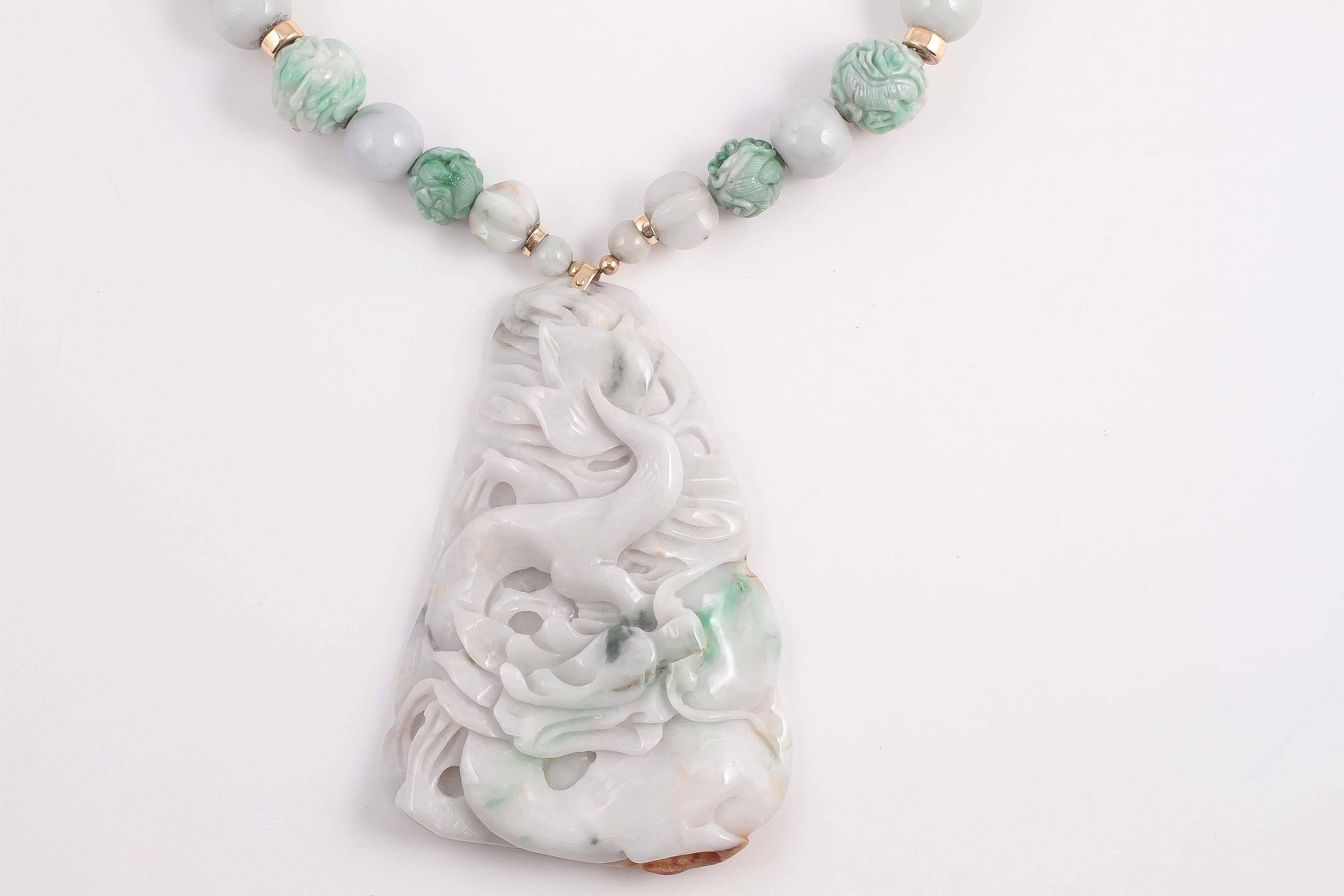 Boldly and artfully carved jade pendant suspended from polished and carved jade beads. A testament to the craftsmen from the East.   