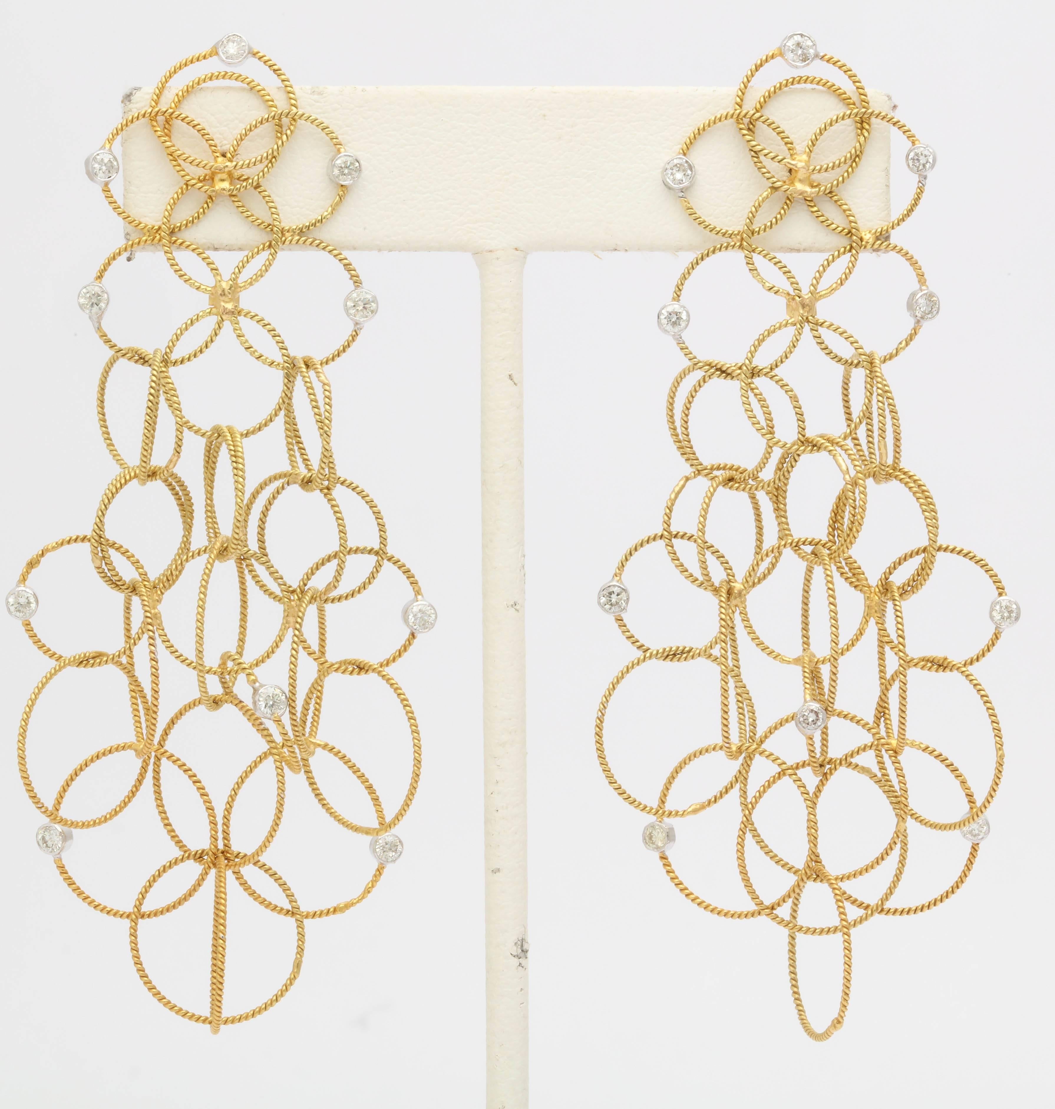These spectacular dangling earrings are 2 1/2 in. long.The white diamonds are 1.12 tw. The metal is a gorgeous rich yellow 18 kt gold.The earring looks rich but is light weight. The loops are interlocked and move beautiful as you wear them. Also