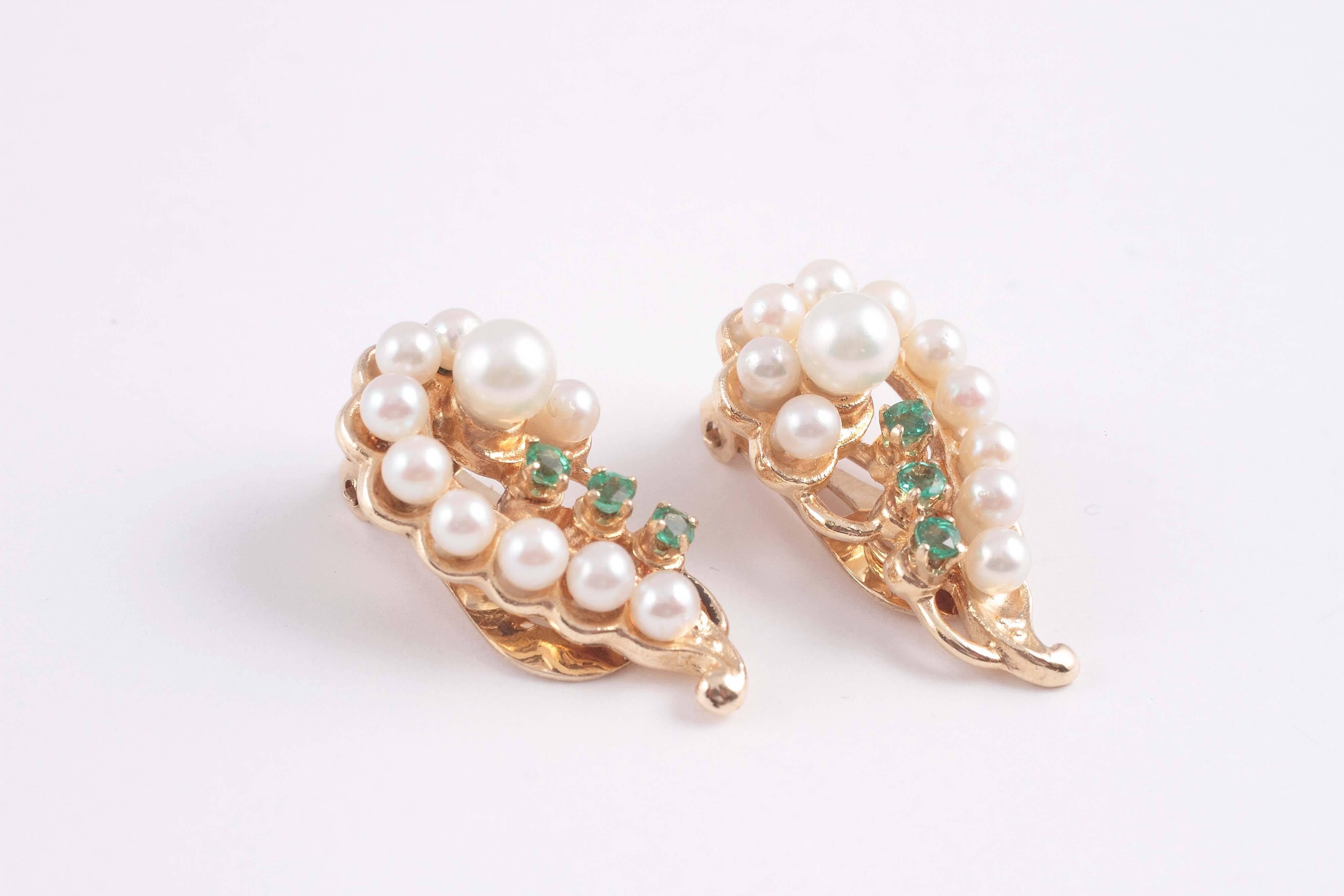 14 karat yellow question marks with cultured pearls and accented with bright emeralds.  The perfect color to offset the color white.  