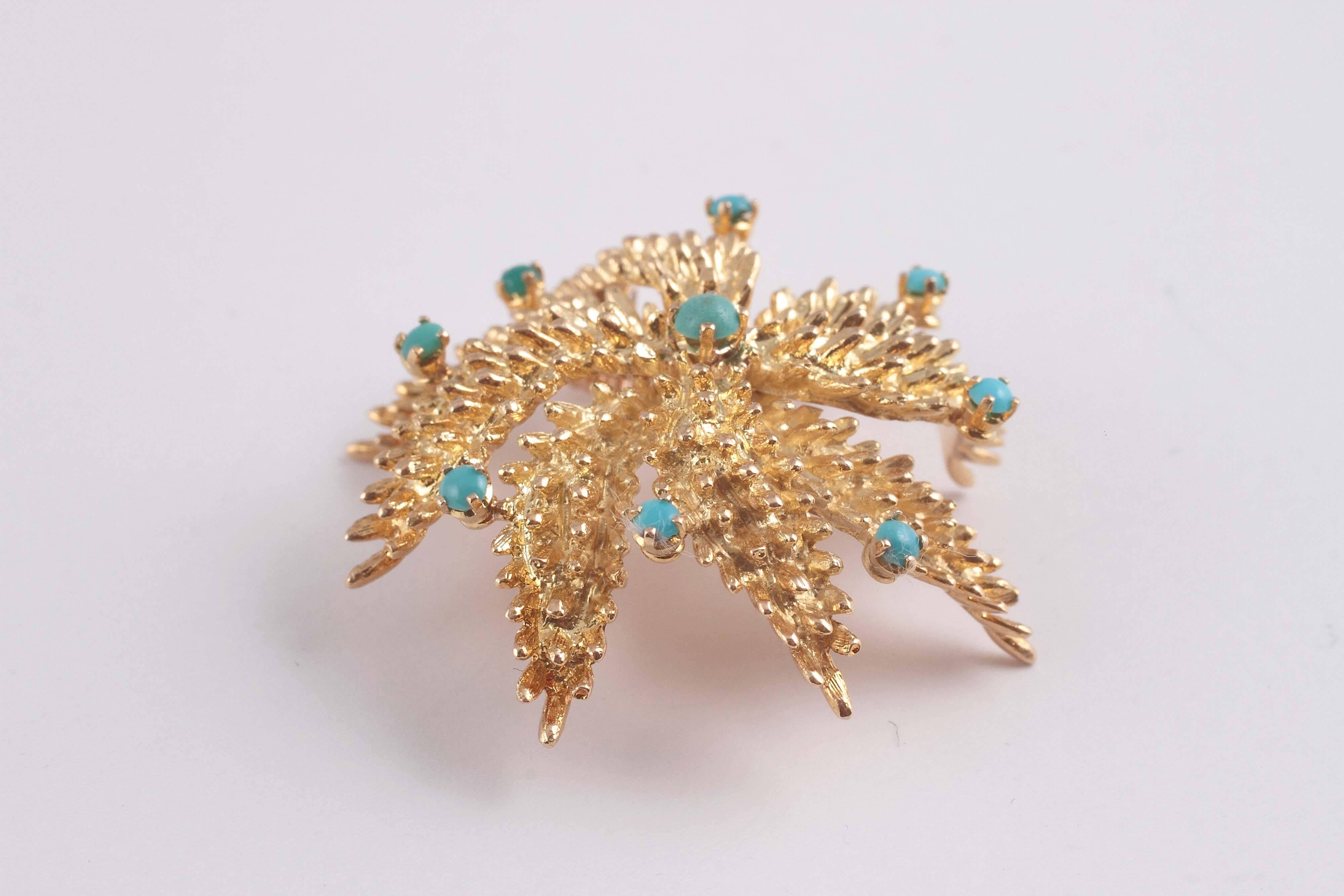 18 karat textured gold in a spiral star shape with turquoise beads.  A fun look for any outfit. 