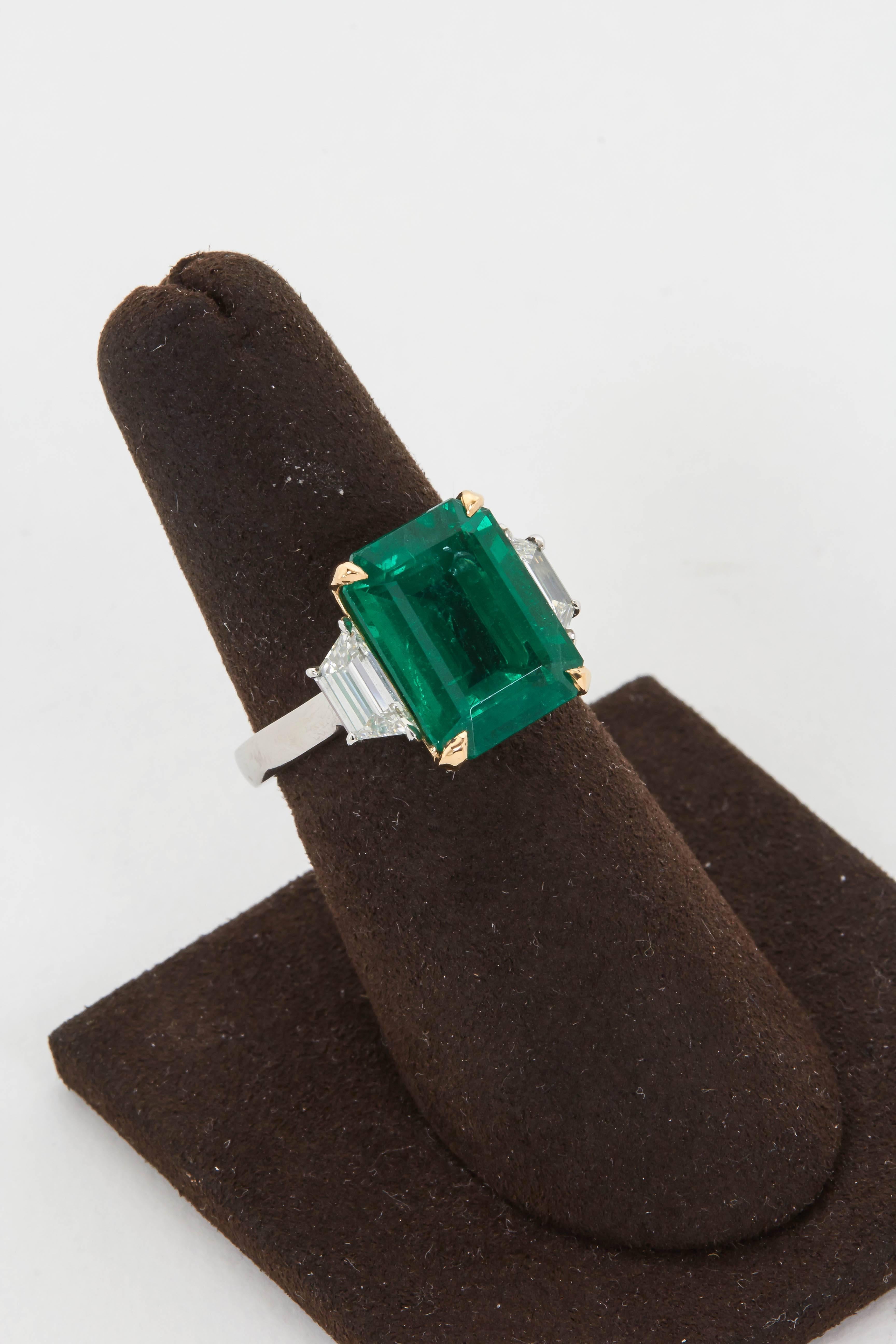 

An extremely vibrant emerald. 

6.95 carats GIA certified set with .88 carats of custom cut side diamonds in a handmade platinum and 18k mounting. 

A high quality emerald ring in a wearable and timeless design.