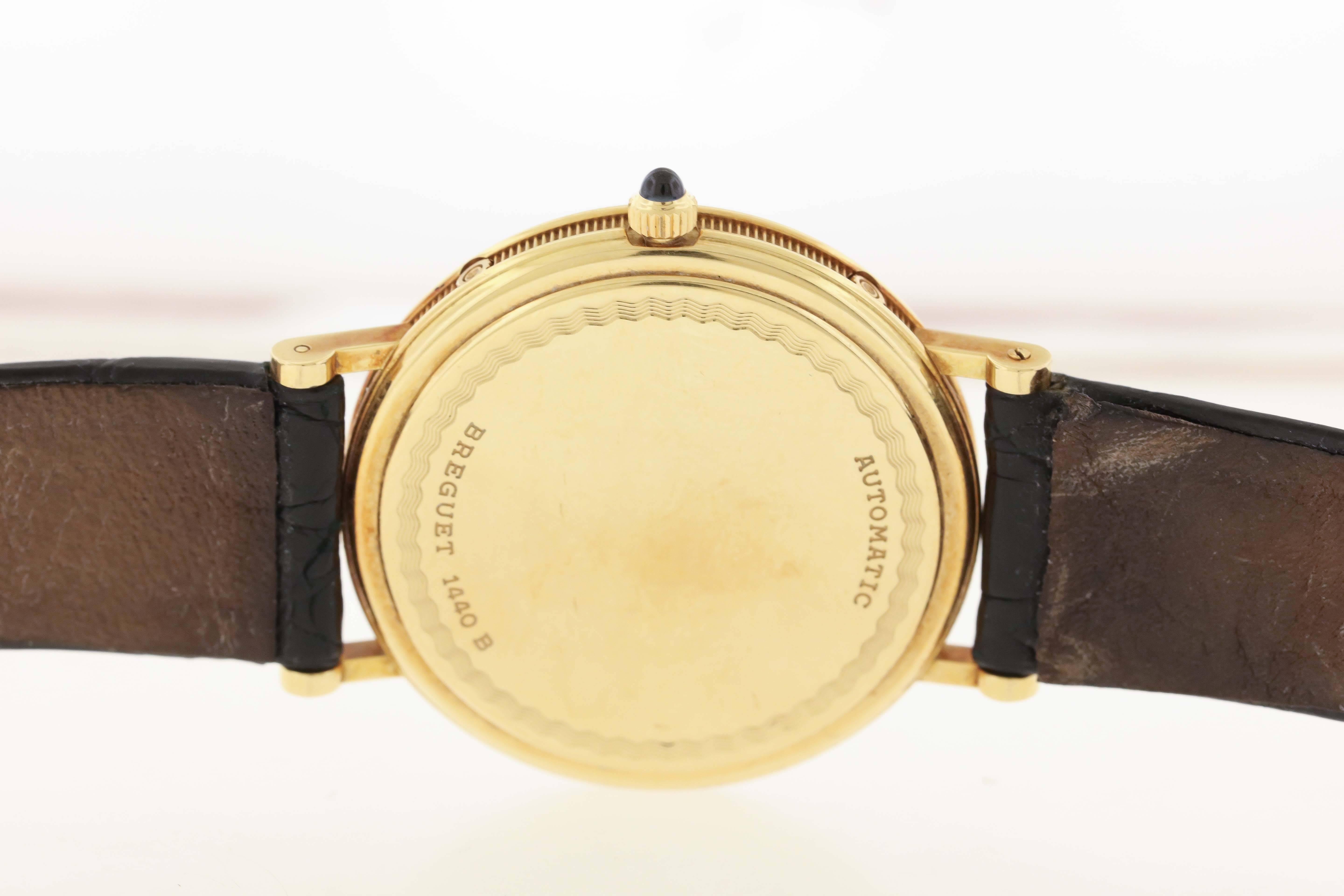 18K yellow gold Breguet Classique Ref. BA3330, circa 2004, is a self-winding thin moonphase calendar wristwatch. The 36mm case has a snap back with engraved border and unique number, reeded band, rounded bezel and sapphire-set crown.  The two tone