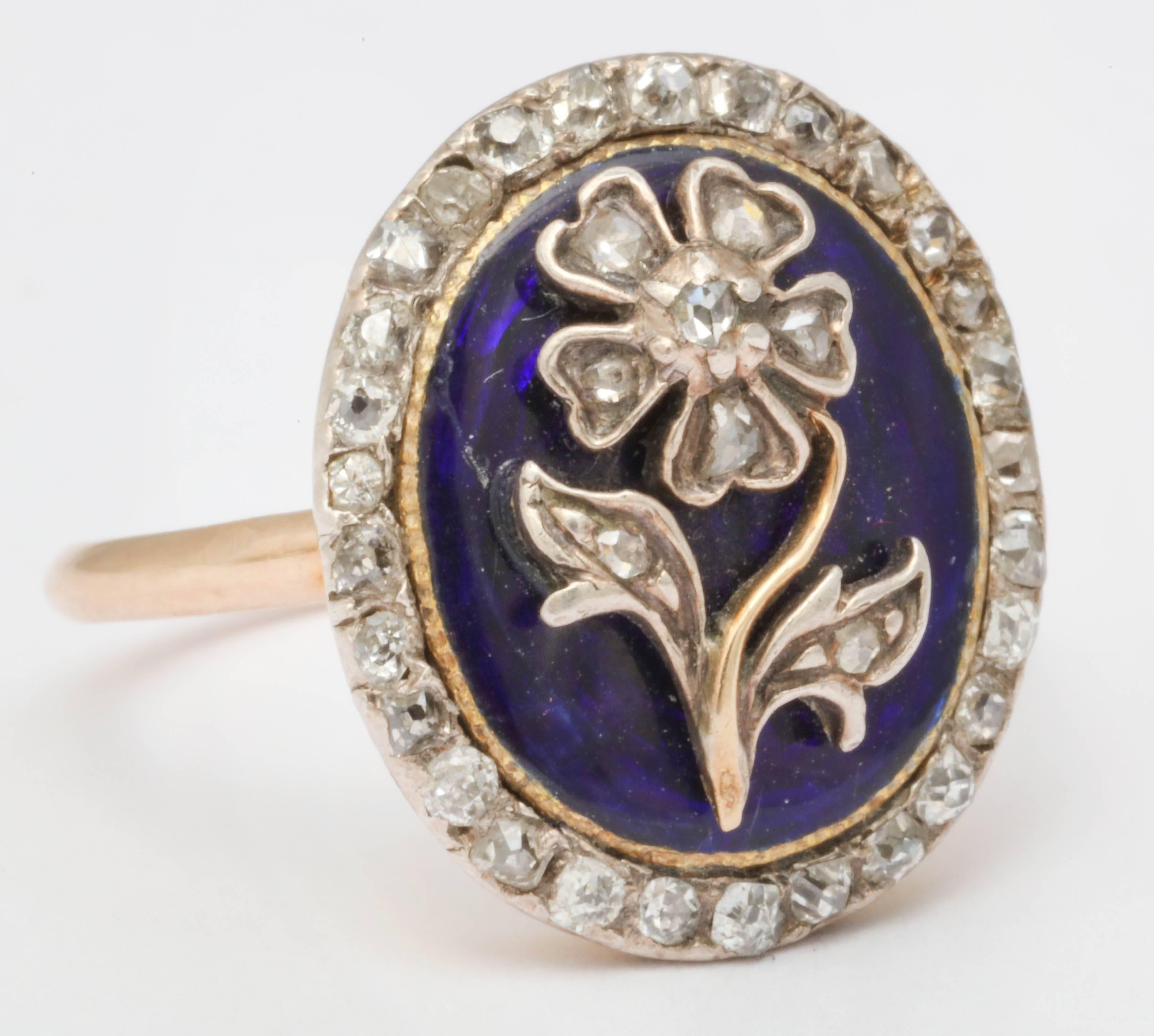 A magnificent example of early Victorian jewelry both in quality and symbolism. A ring like this would have been a very personal piece with is hidden locket compartment underneath the head. The ring is blue enamel topped by a stylized daisy set with