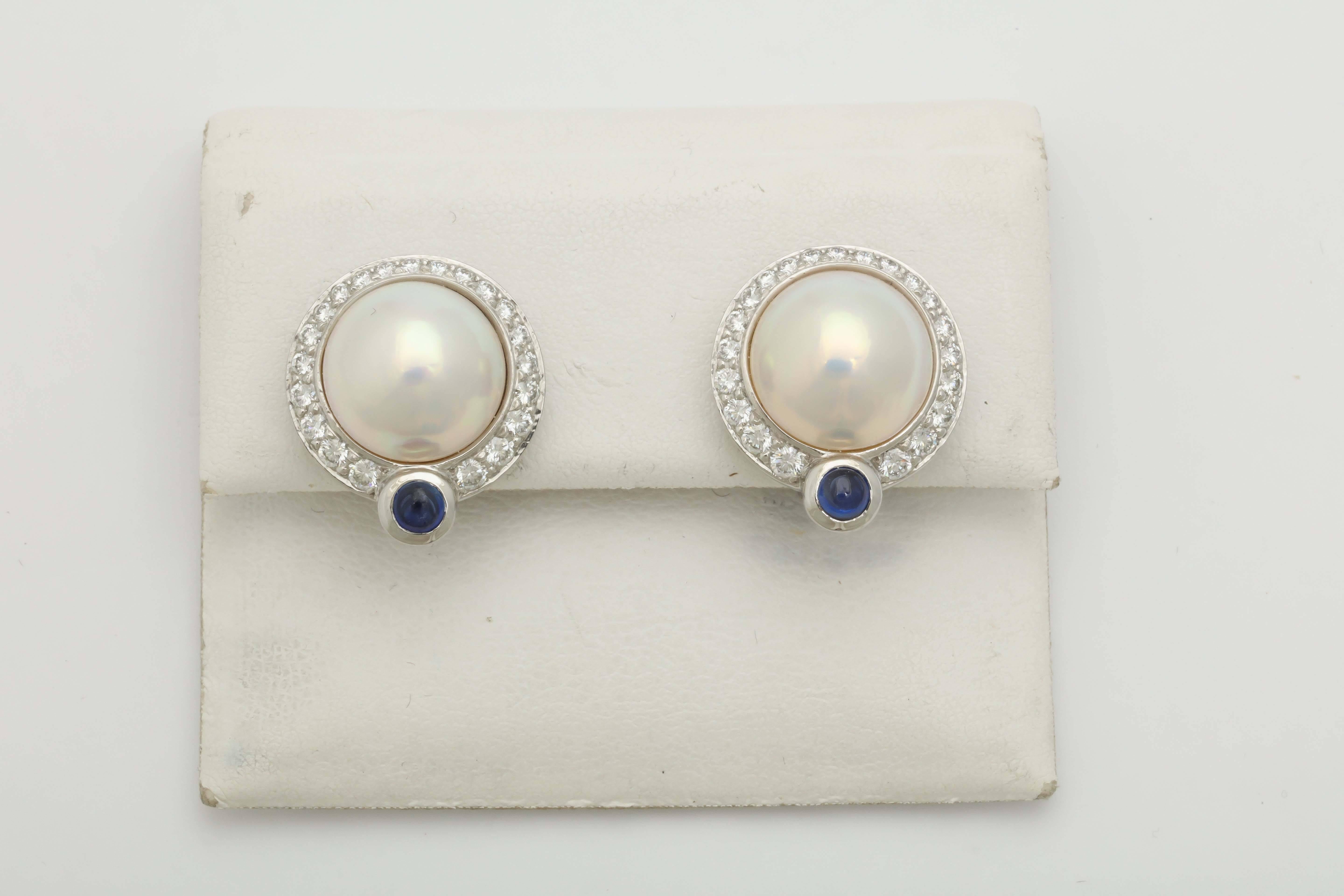 One Pair Of Platinum Circle Shaped Earrings Embellished with numerous Full Cut Diamonds Weighing Approximately 2 carats And Centering a n 11mm High Quality & Beautiful Lustre Mabe' Pearl. On Bottom Of Earrings Are 2 Beautiful Color Cabochon