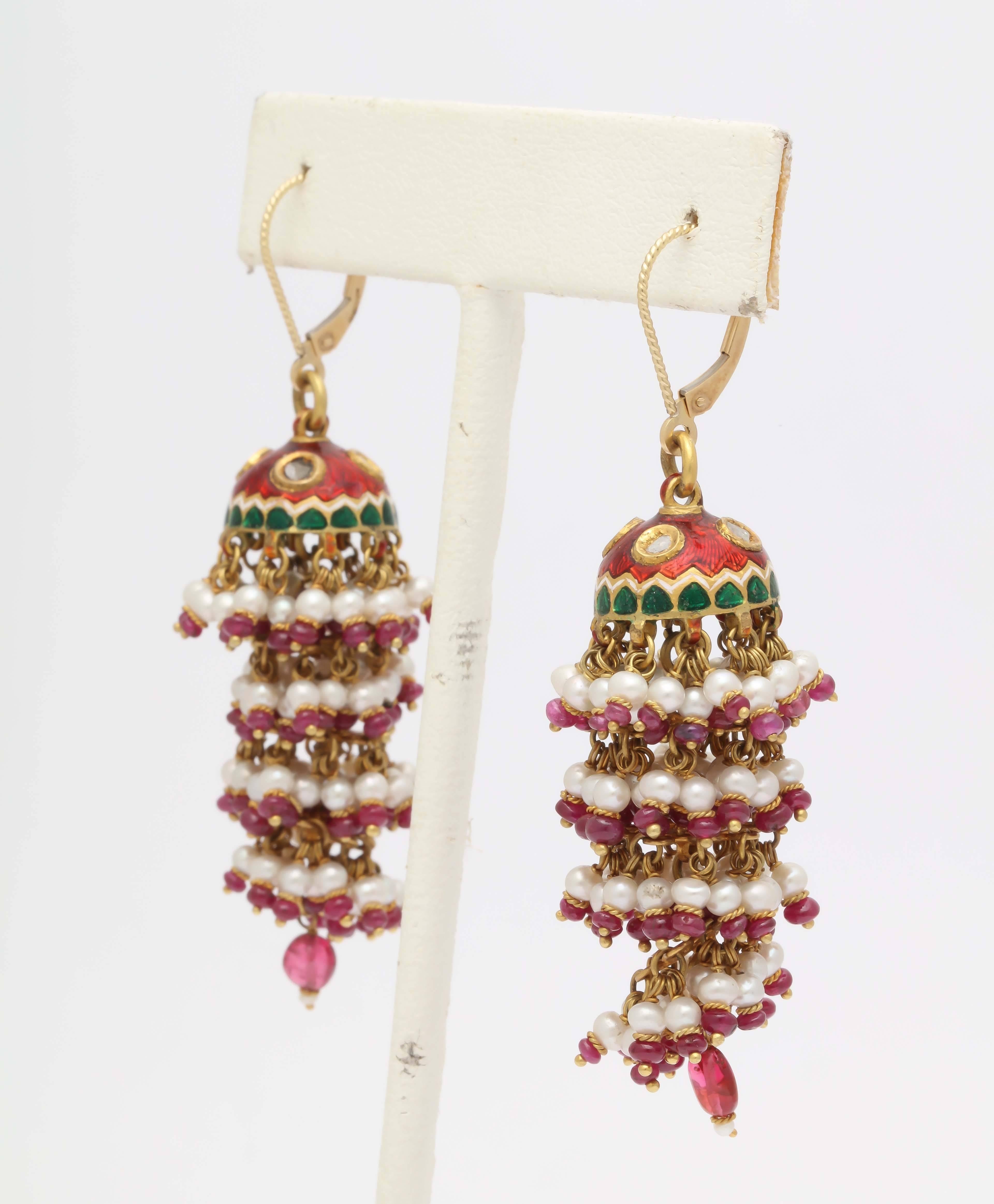 These stunning layered earrings are handmade in India. The caps are 18kt gold , diamond slices and enameled with red and green enamel in the traditional style of Northern India. Each dangle is hand wired with pearls, rubies and 18 kt gold. The