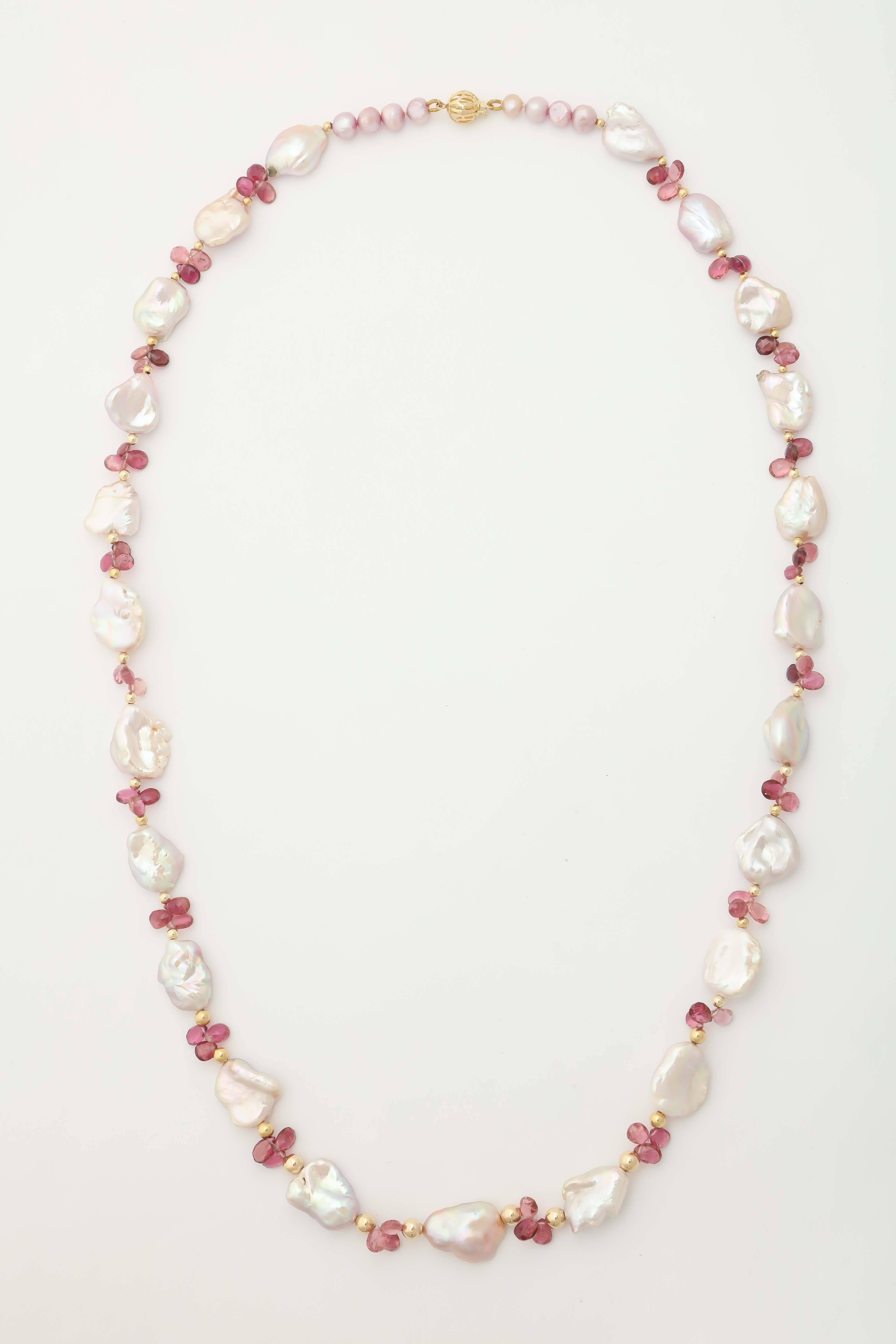 This pastel pink baroque fresh water pearl and pink tourmaline briolette necklace is 28 1/2 in. long. The gold balls separating the pearls are 14 kt gold and so is the filigree clasp. A great necklace with light and airy summer clothes. The pearls