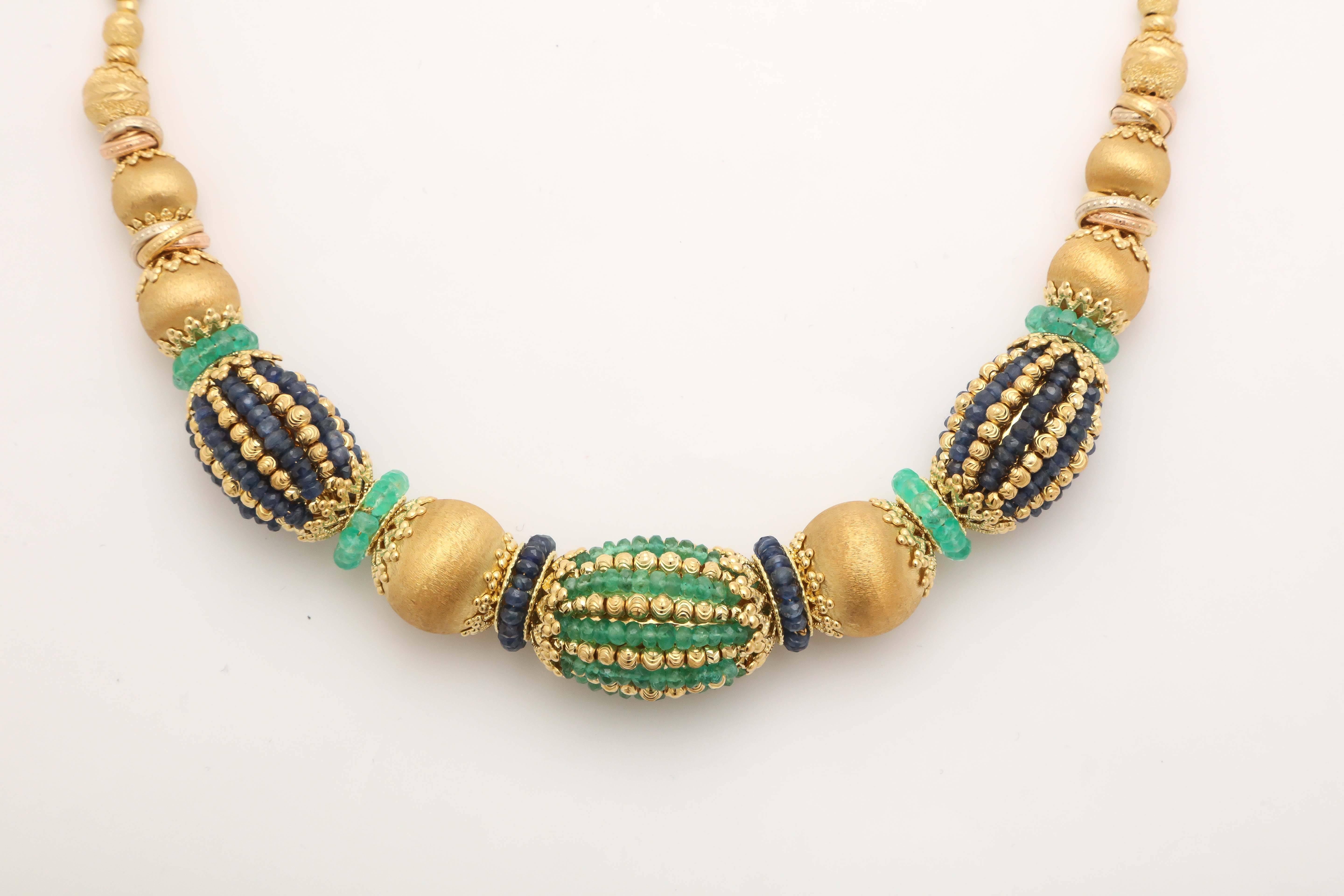 Exotic engraved Gold Beads and Rondels alternately covered with Emerald Beads and Sapphire Beads.  Very Luxe and rich looking.  Signed with tab inscribed 